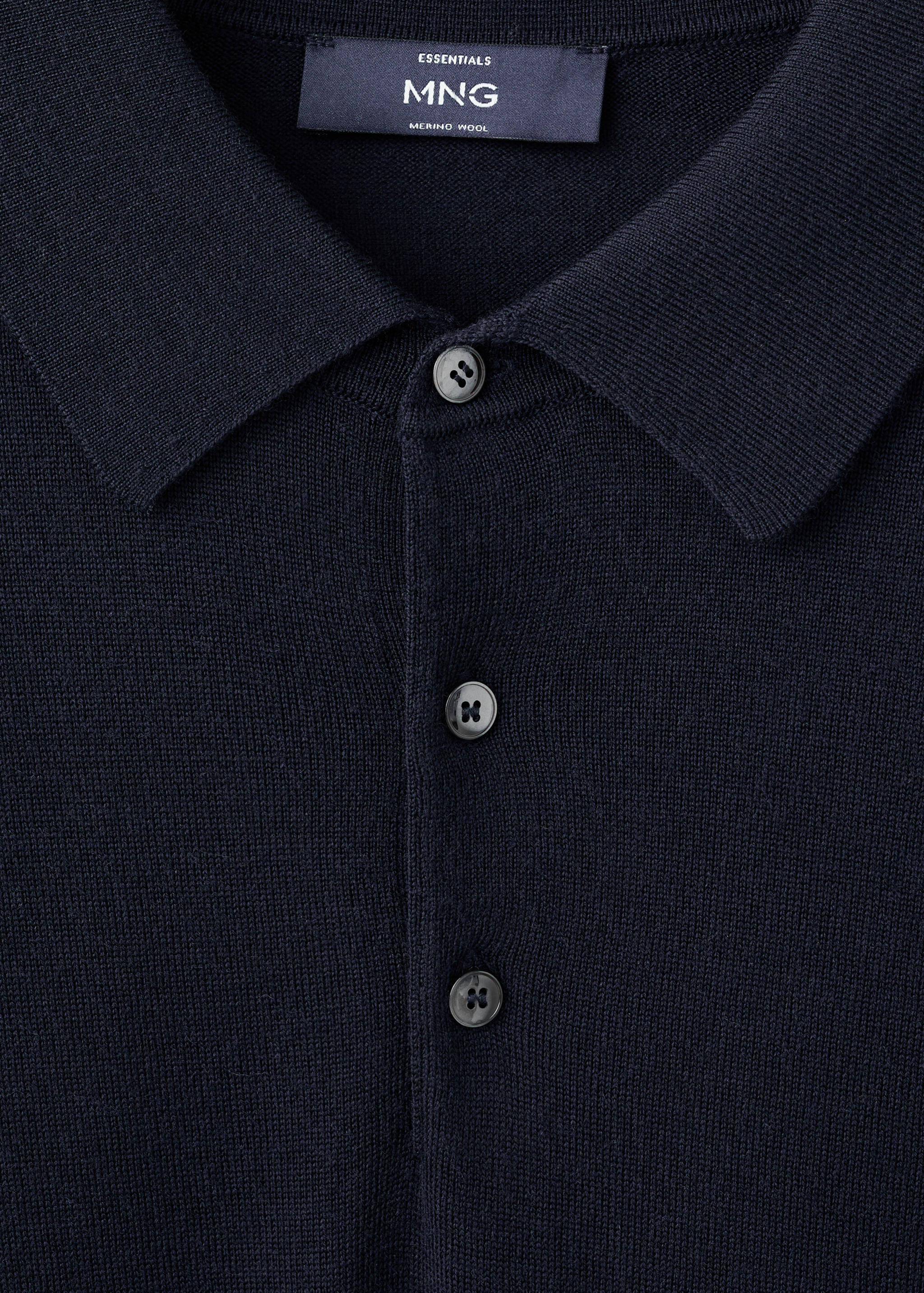 Close-up of a navy merino wool polo shirt collar and button placket.