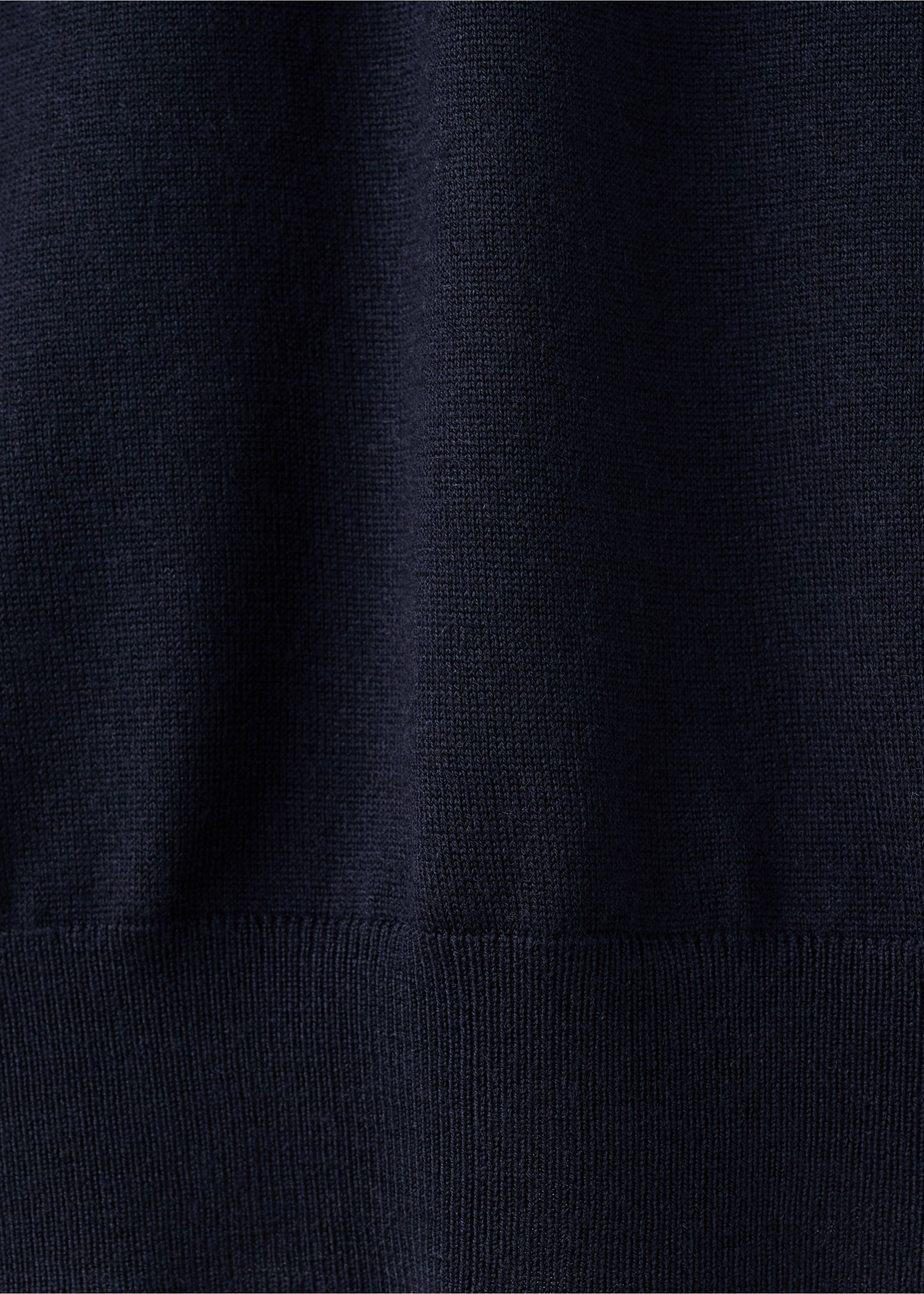 Close-up of the fine knit texture and ribbed hem of a dark navy blue polo., Navy. Ref: 27051283-00.