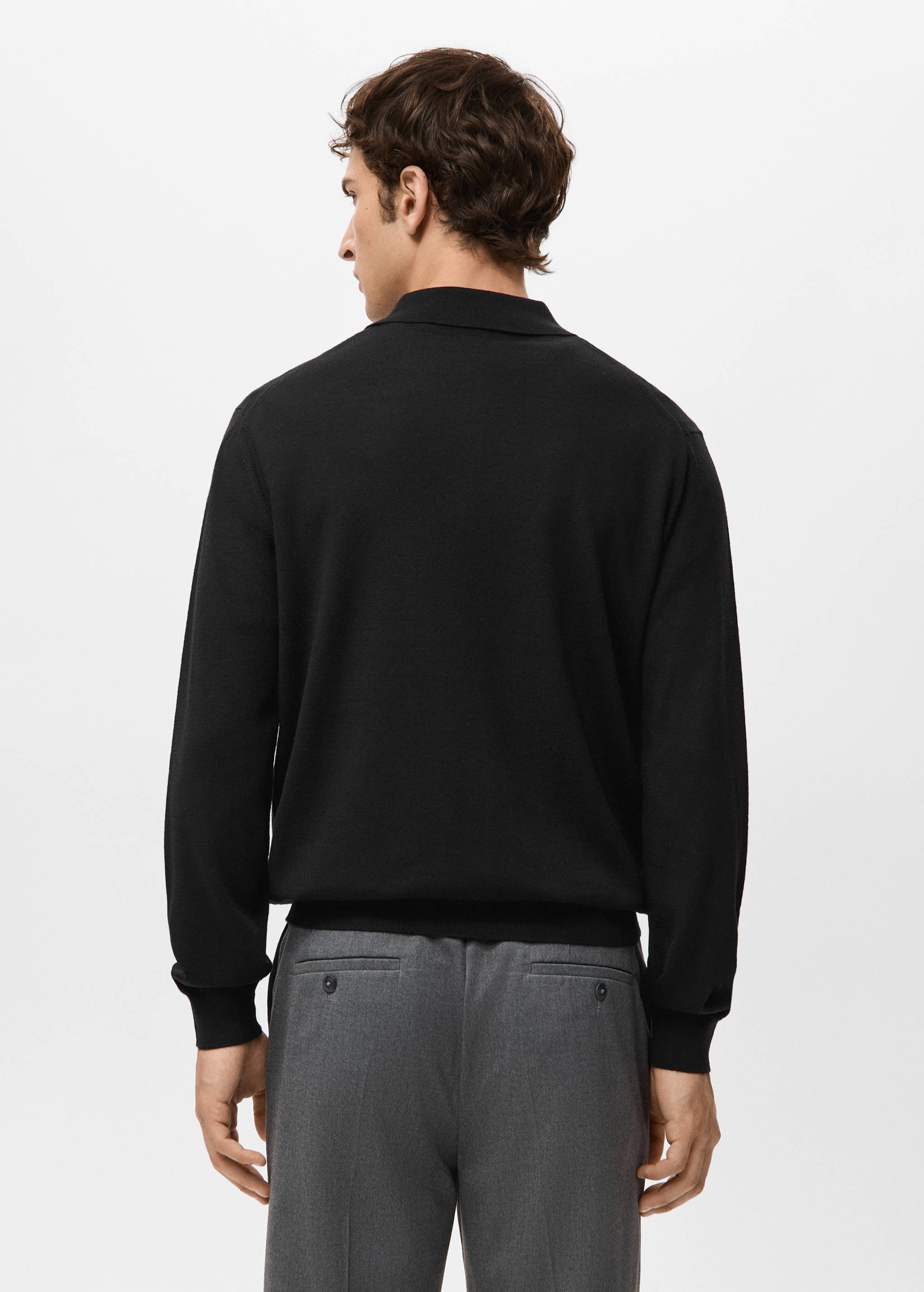 Black long-sleeved knit polo shirt seen from the back, featuring a ribbed collar and cuffs.
