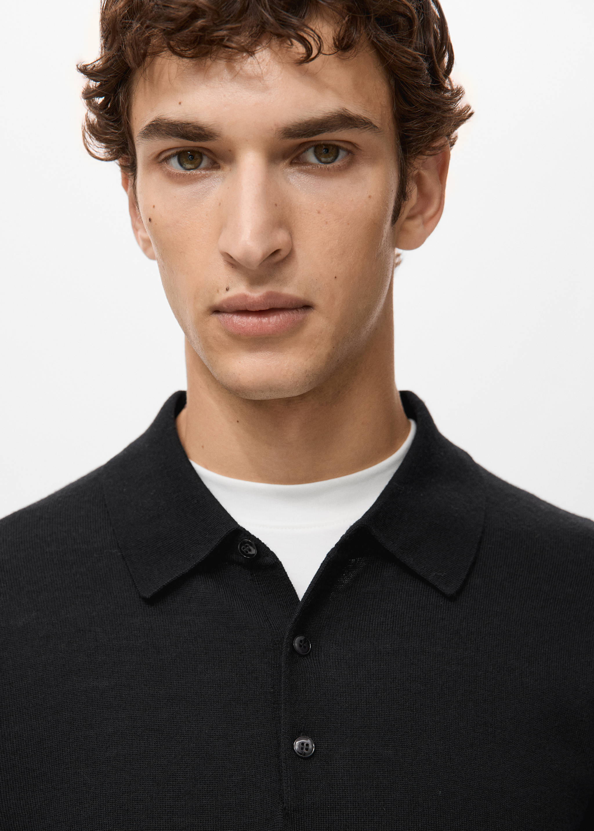 Black knitted polo shirt with a classic collar and button placket.