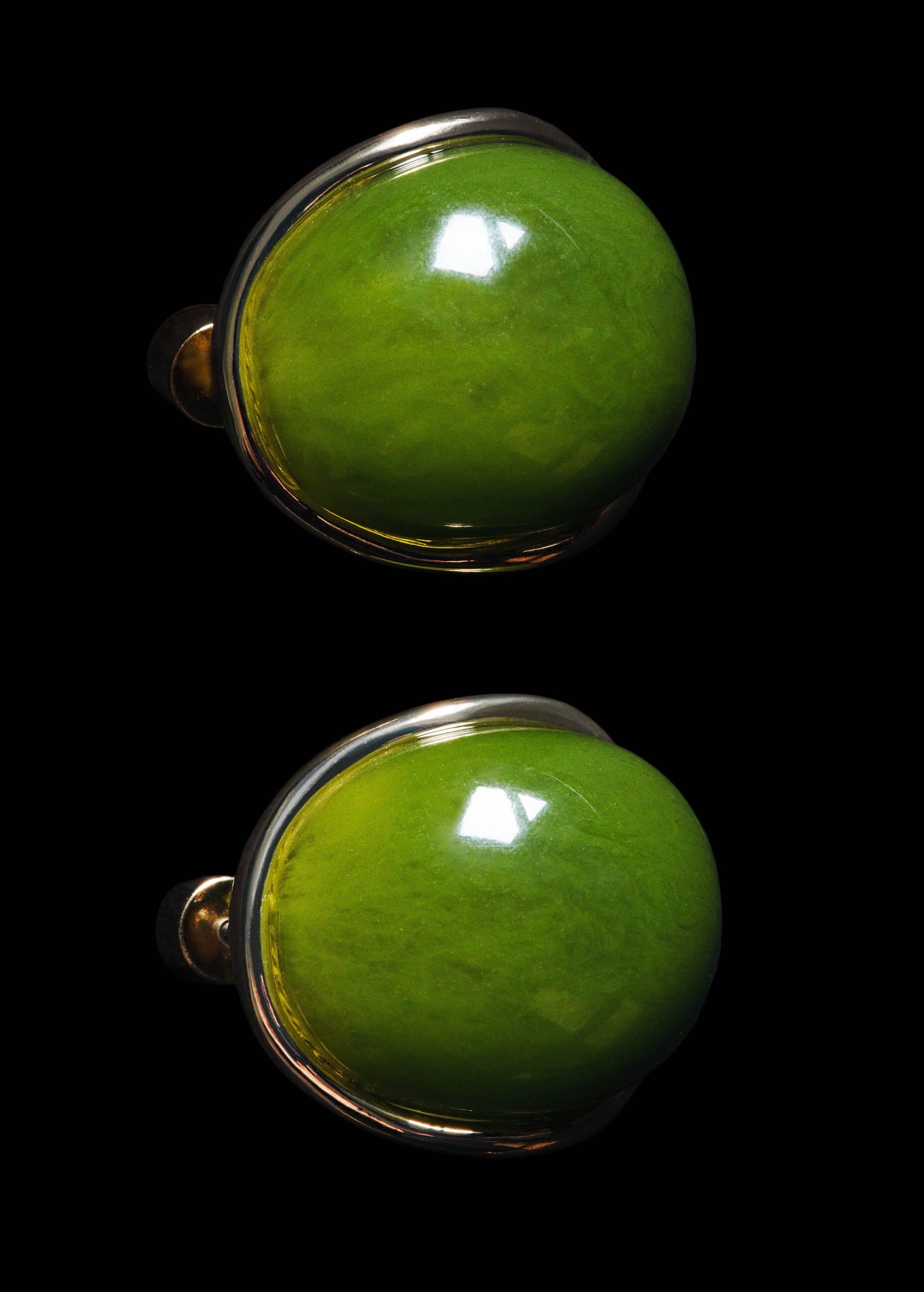Large green domed earrings with metallic settings.