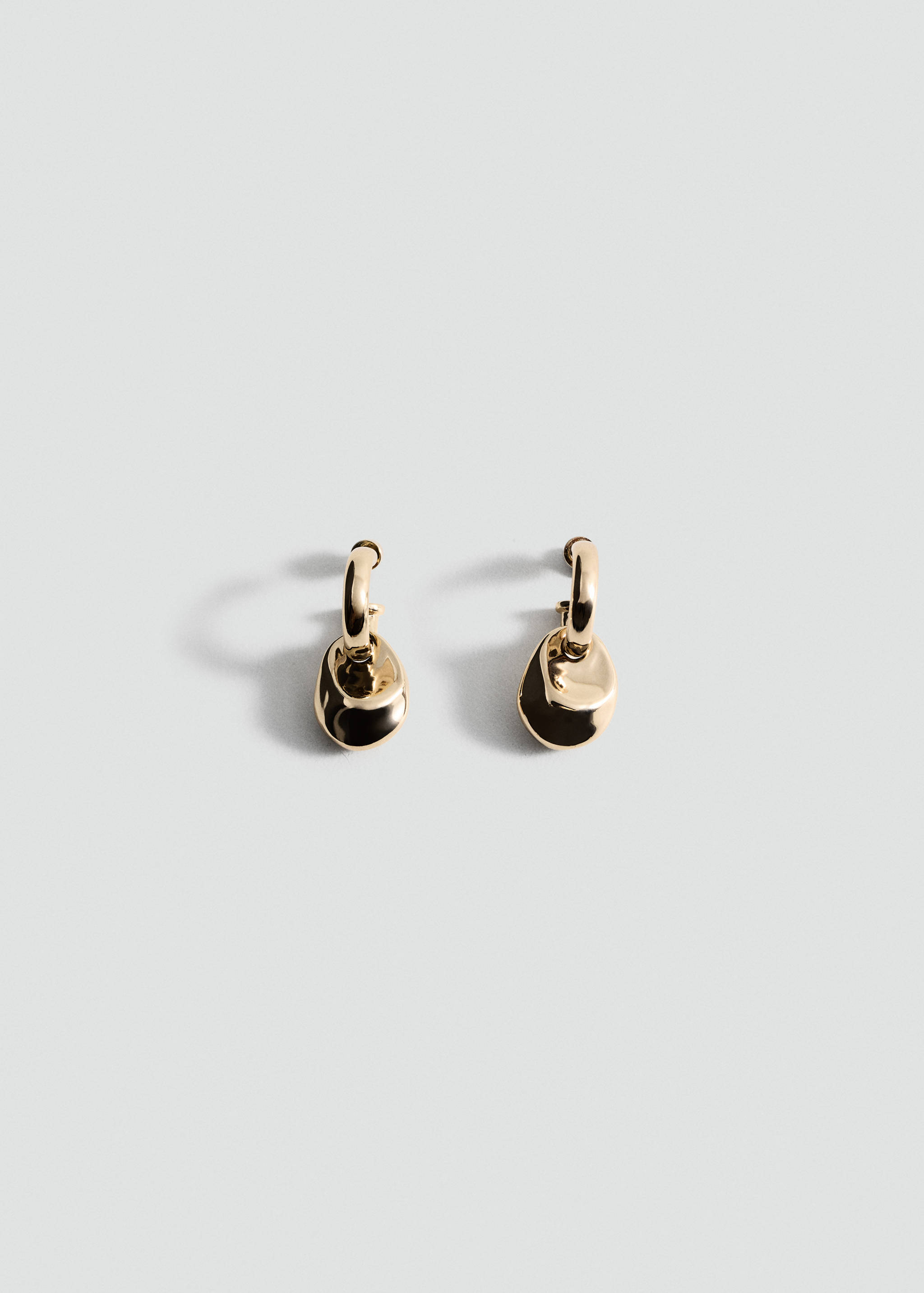 Gold-tone earrings with small hoops and irregular drop pendants.