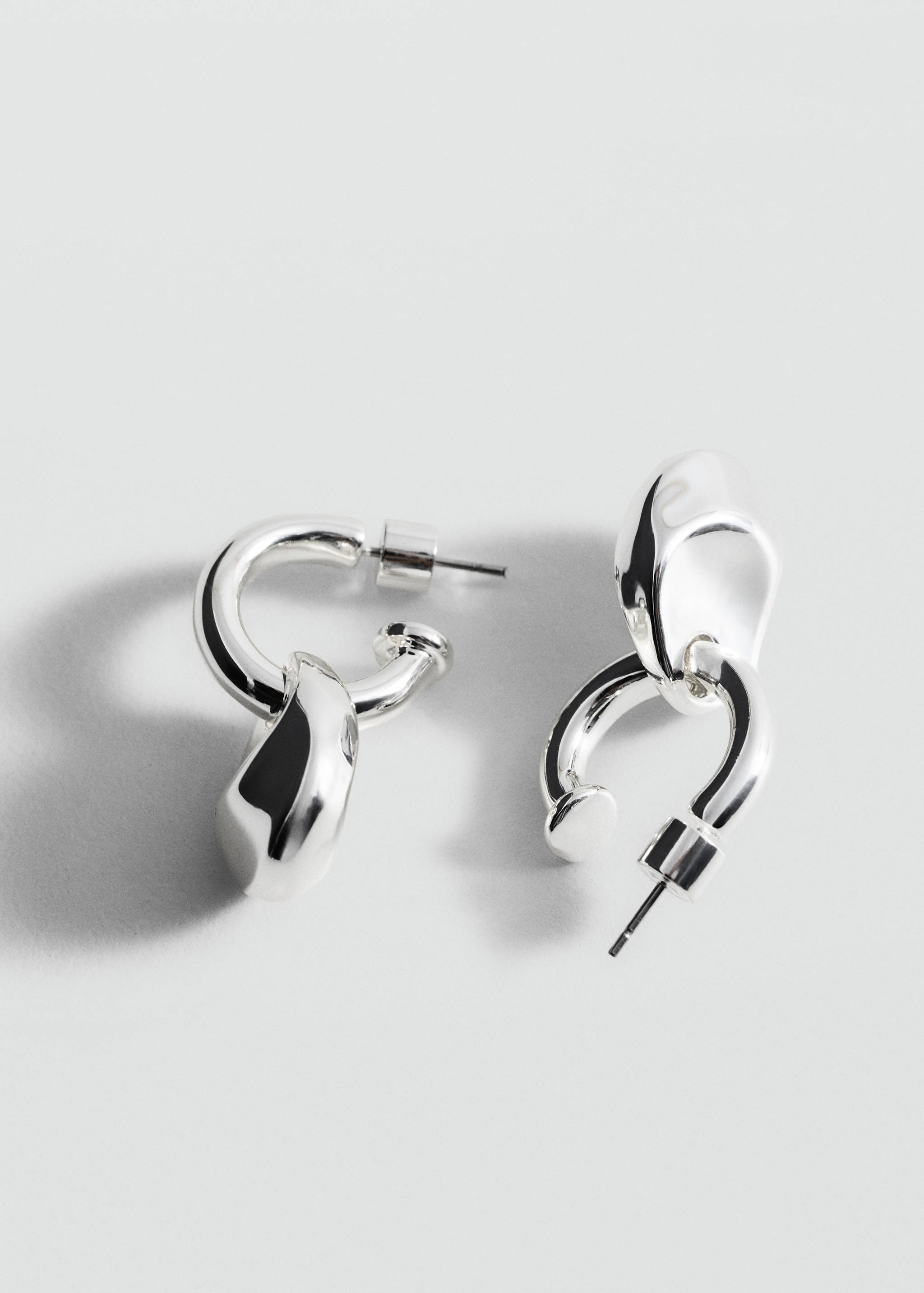 Silver-finish geometric metal earrings with an interlocking abstract design.