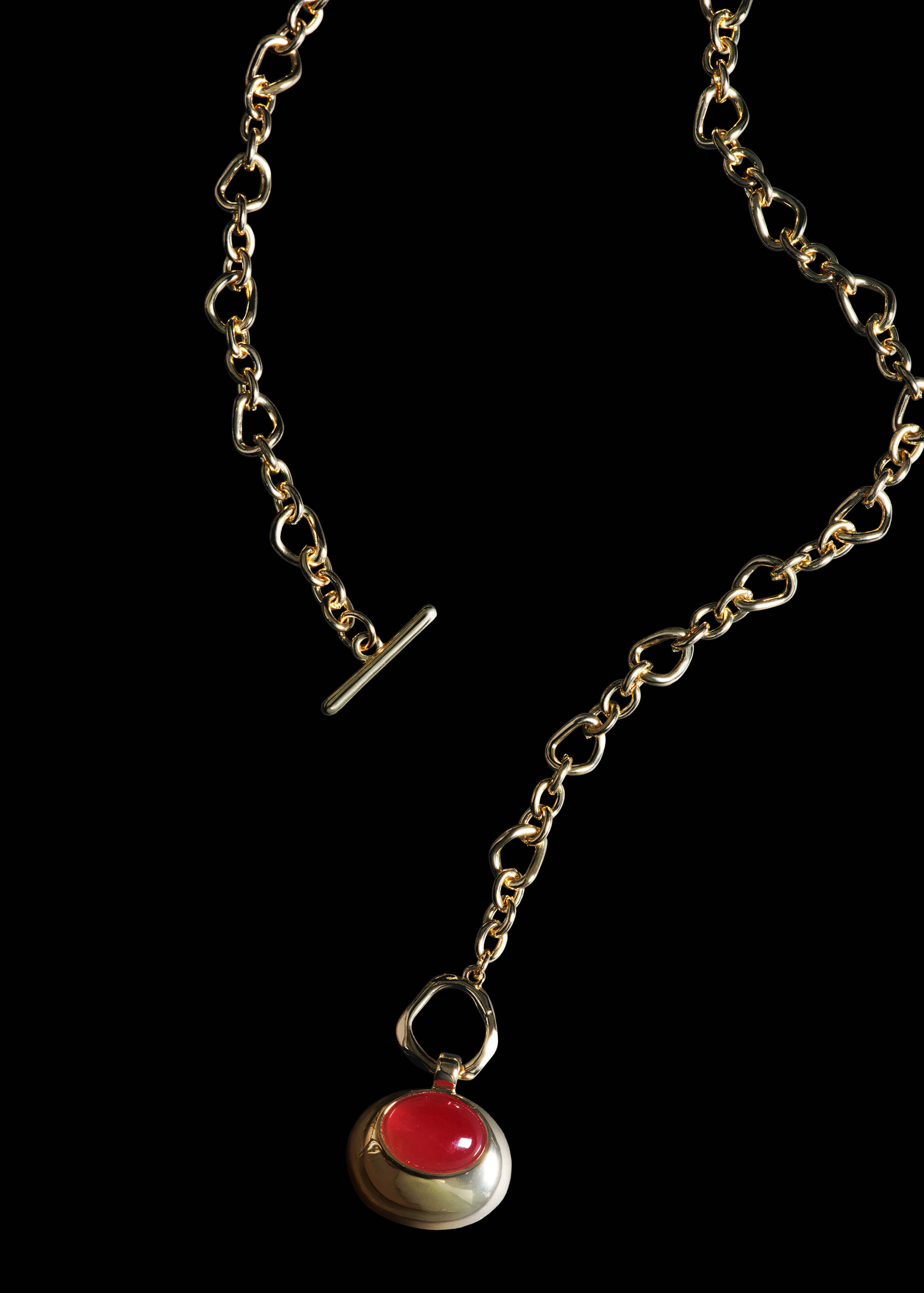 Gold-toned metal chain necklace with irregular links and a red pendant.
