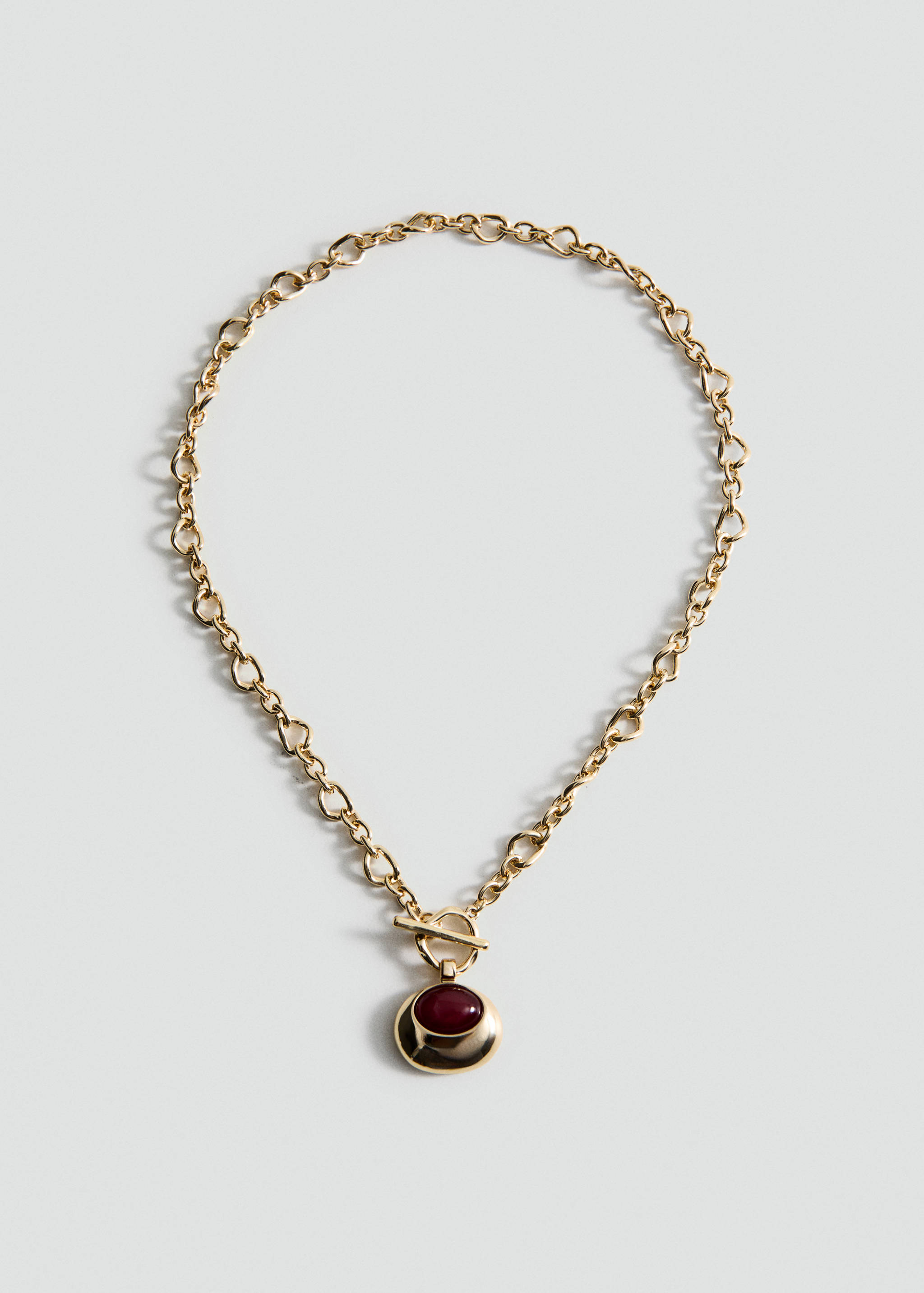 Gold-tone chain necklace with a T-bar clasp and a round red stone pendant.
