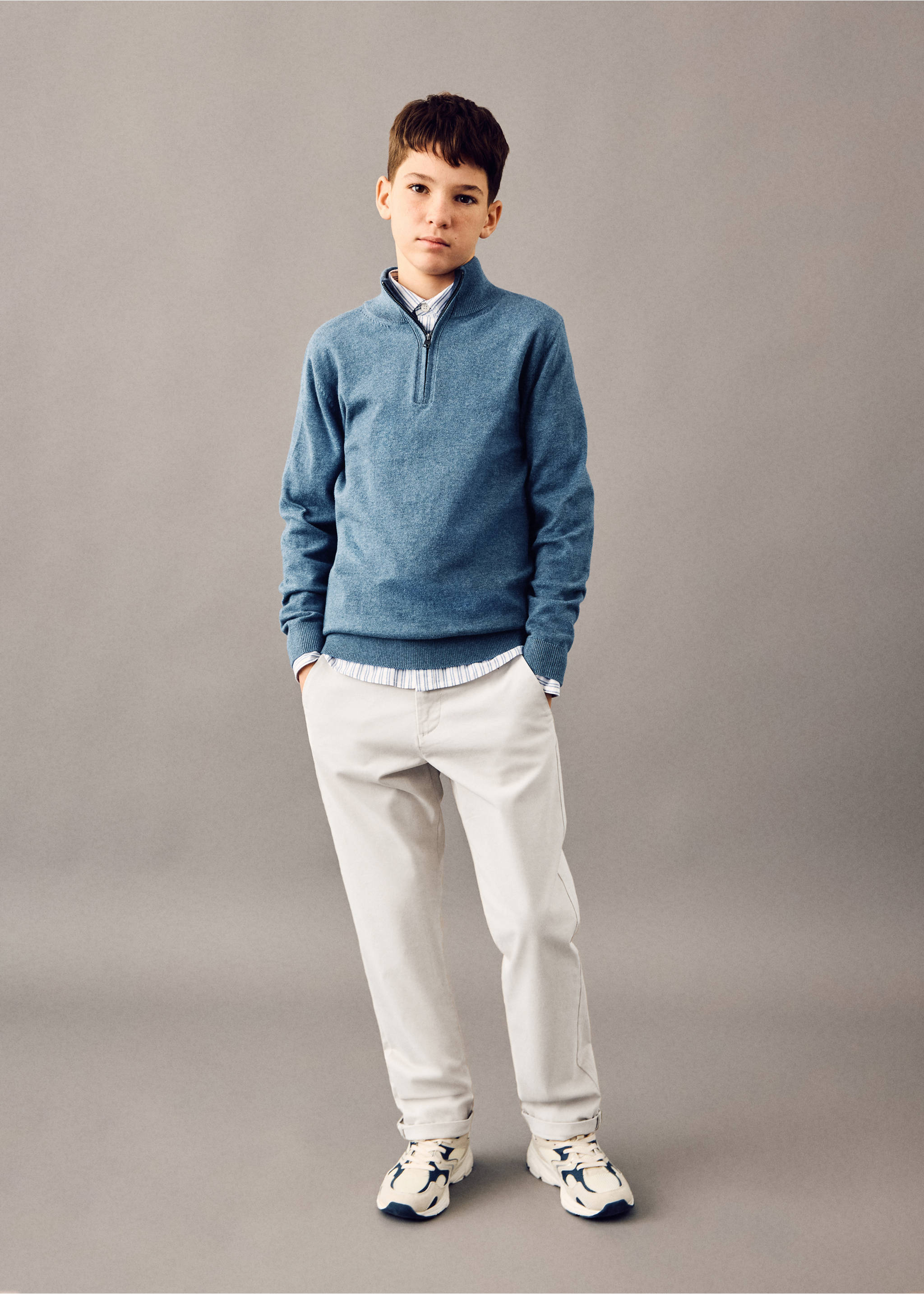 Off-white trousers with relaxed fit and rolled-up cuffs, styled with a blue zip-neck sweater., Ice Grey. Ref: 27054403-00.