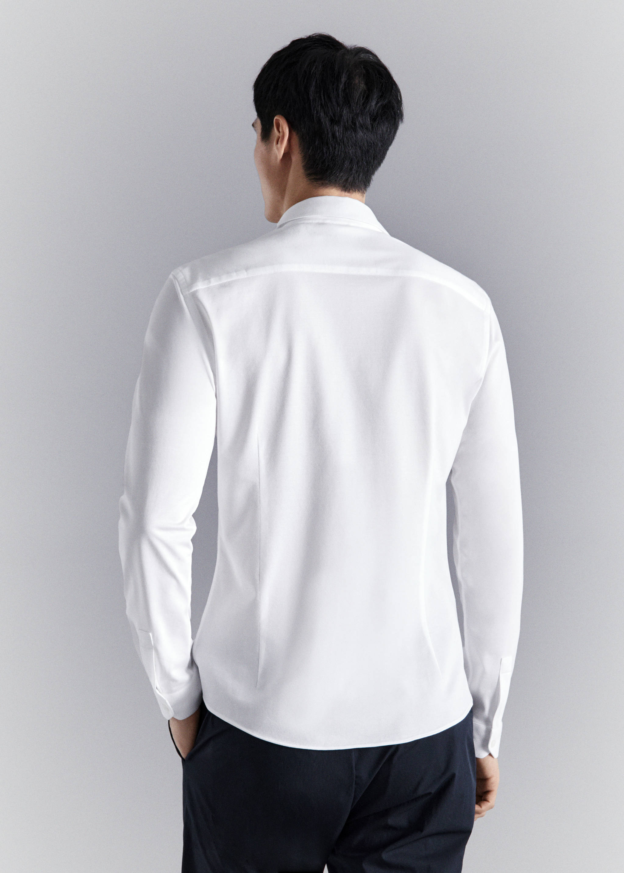 White long-sleeved shirt seen from the back.