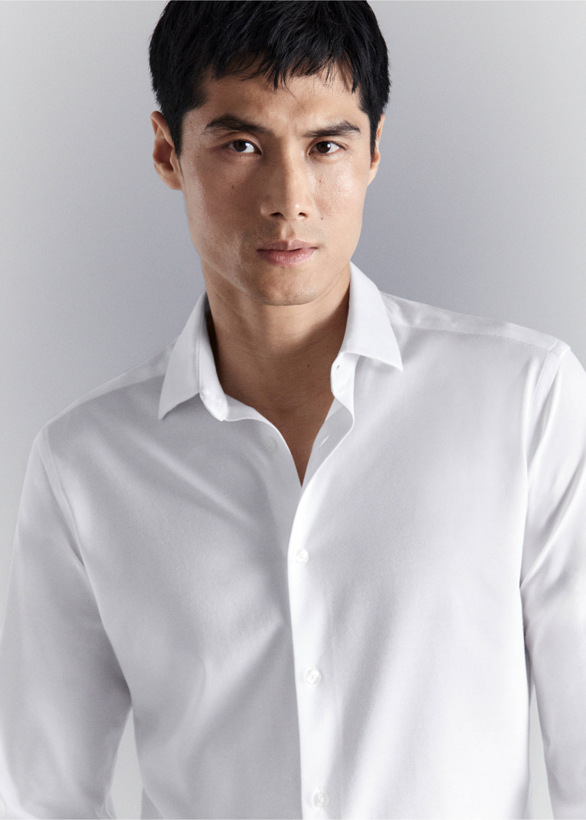 Close-up of a white shirt with a pointed collar and button placket., White. Ref: 27054422-00.