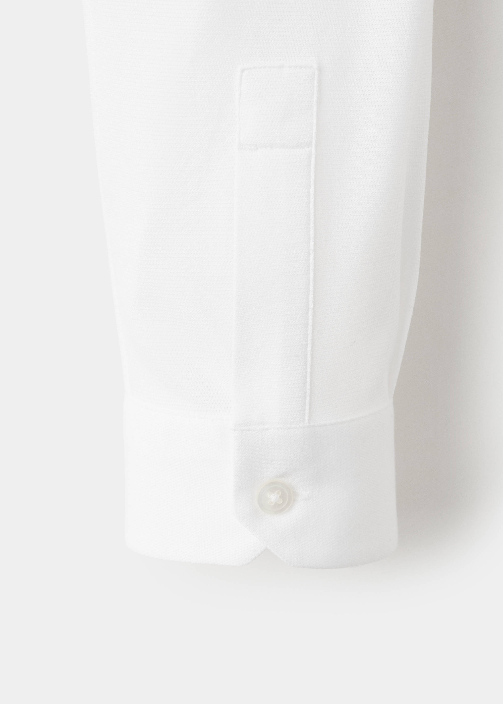 Close-up of a white shirt cuff and fabric detail.