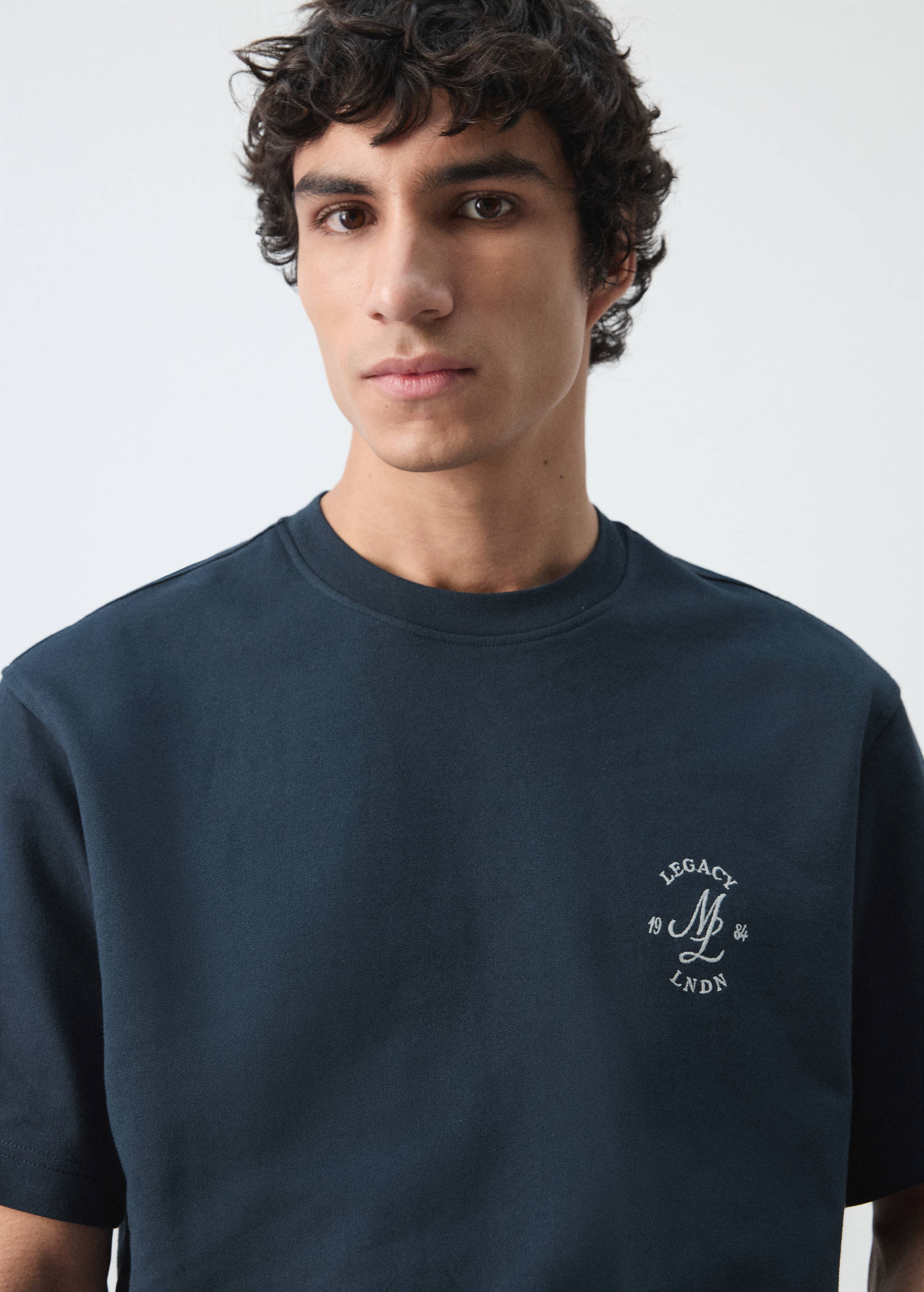 Navy blue t-shirt with a round neckline and white chest graphic.