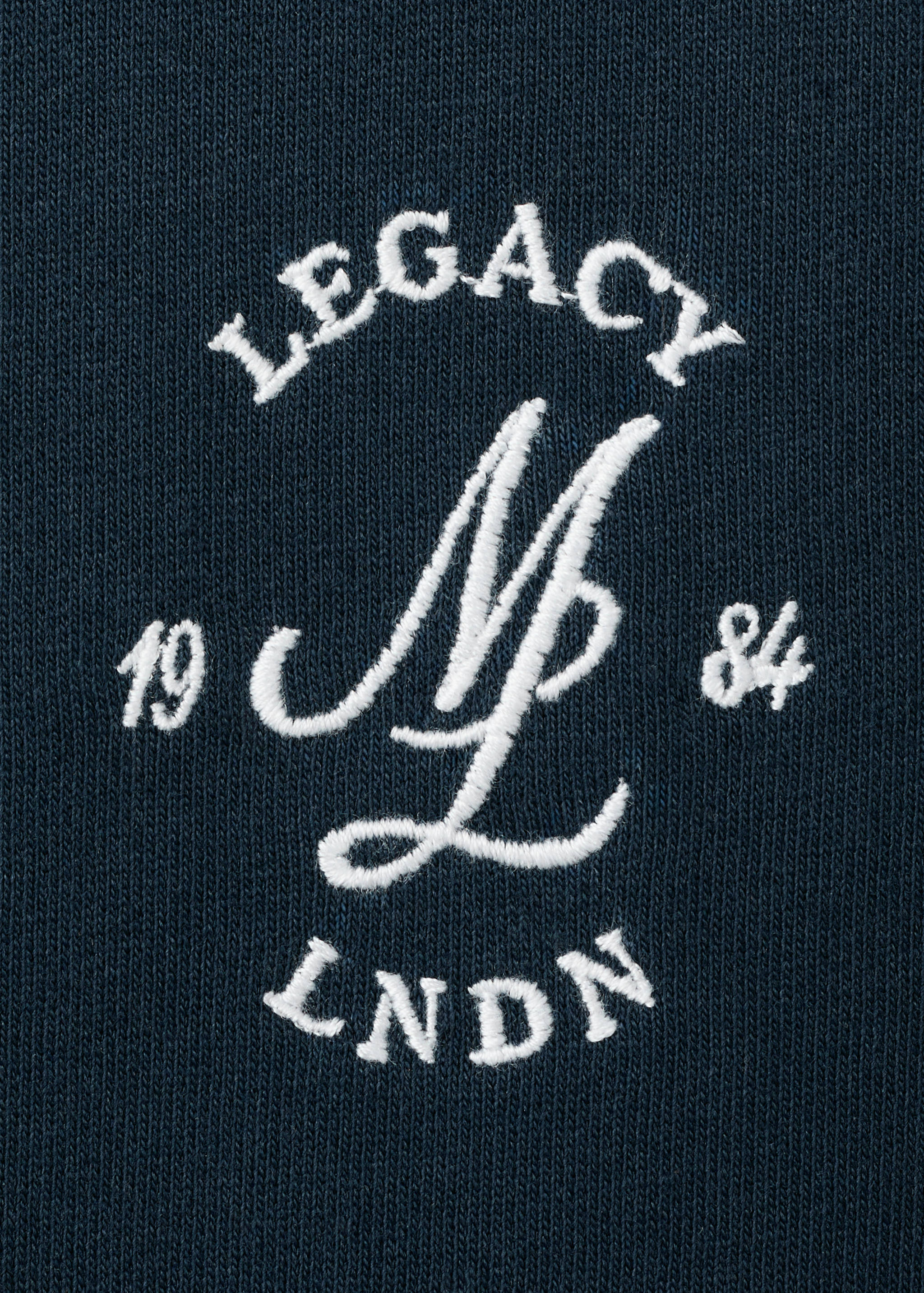 Dark blue t-shirt detail with white embroidered logo.
