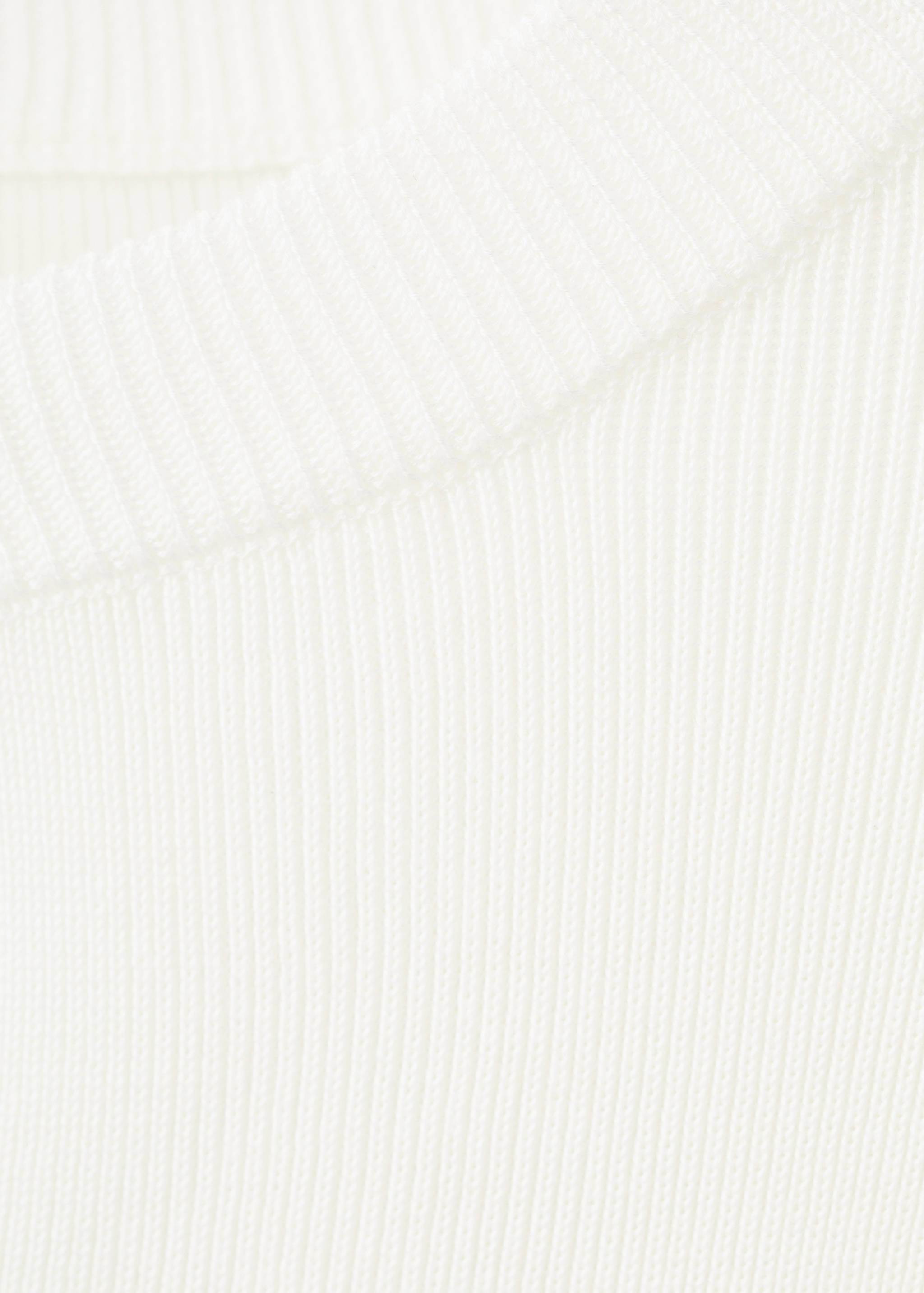 Close-up of the white ribbed knit texture on a cardigan.