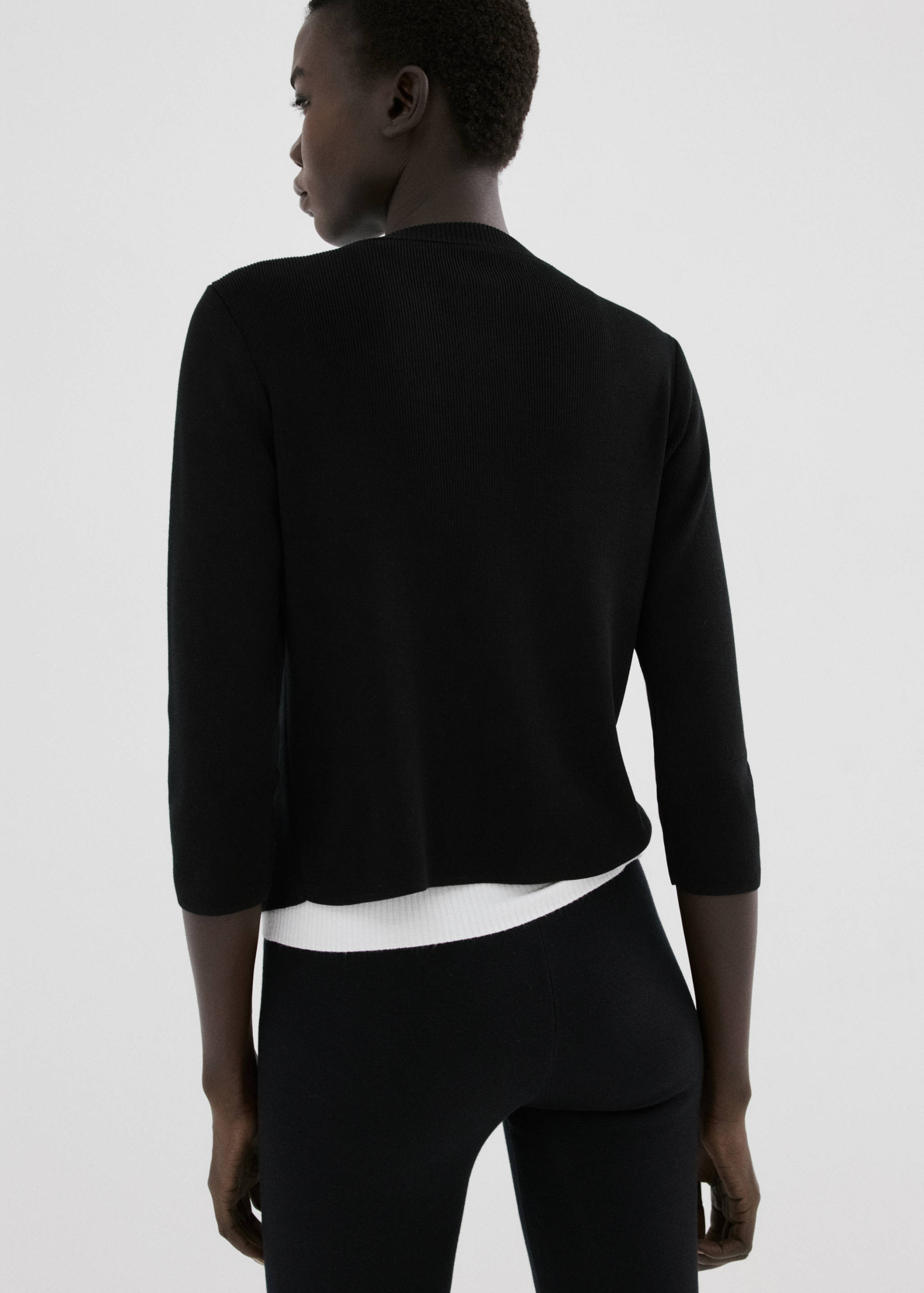 Black cardigan seen from the back, featuring a round neckline and elbow-length sleeves.