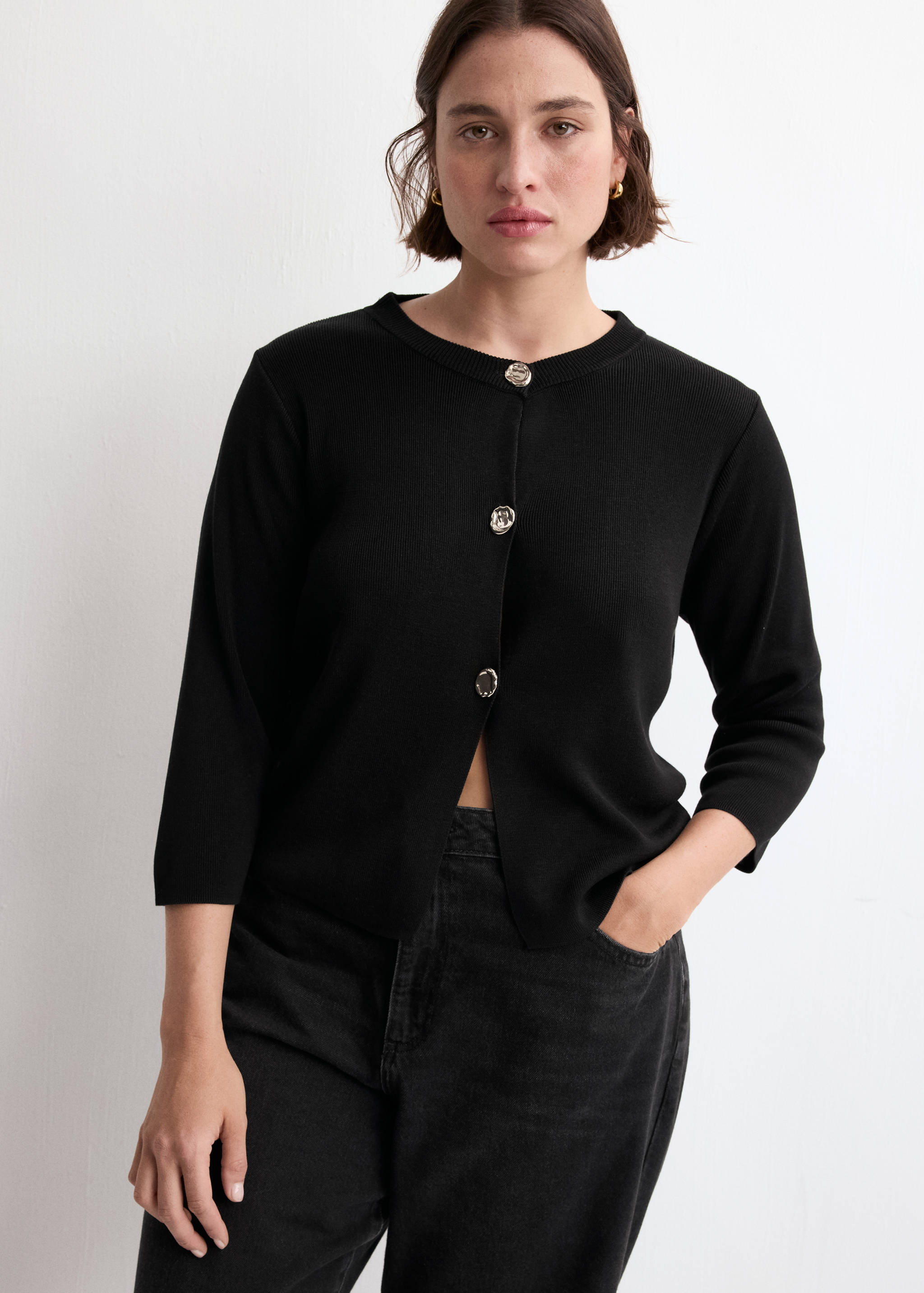Black knitted cardigan with a round neck and silver-toned buttons.