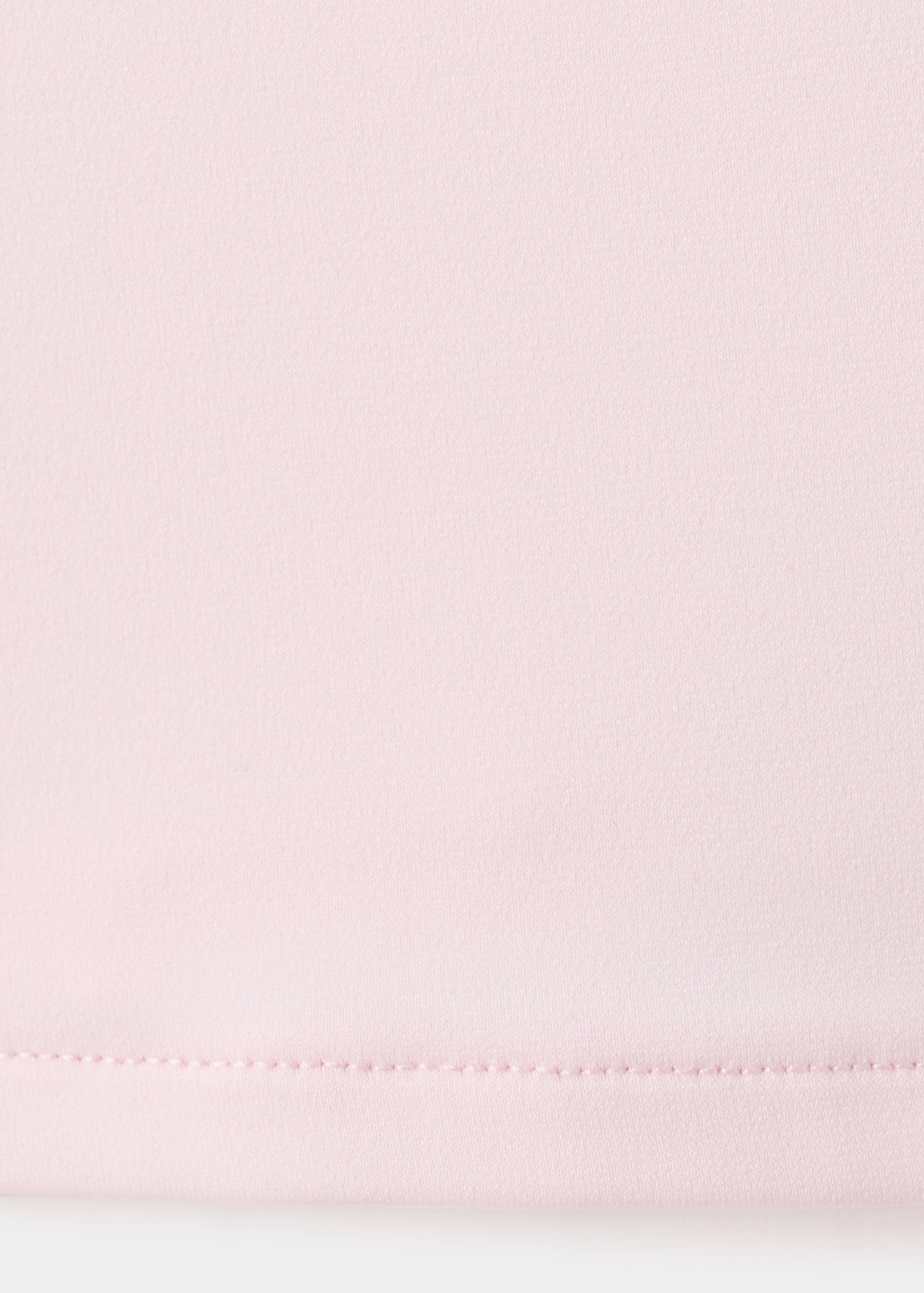 Detalle de tejido del top rosa con bajo pespunteado.