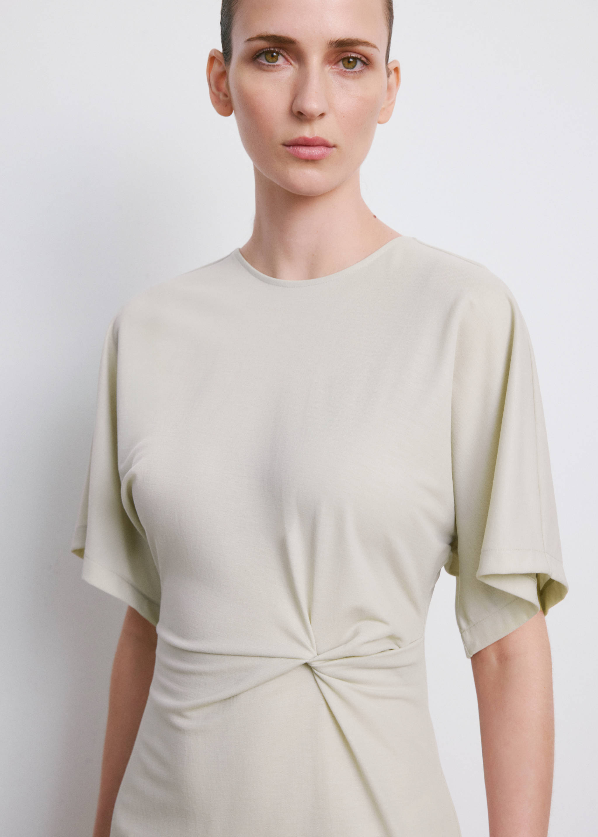 Light green dress with a round neck, short sleeves and twisted waist knot.