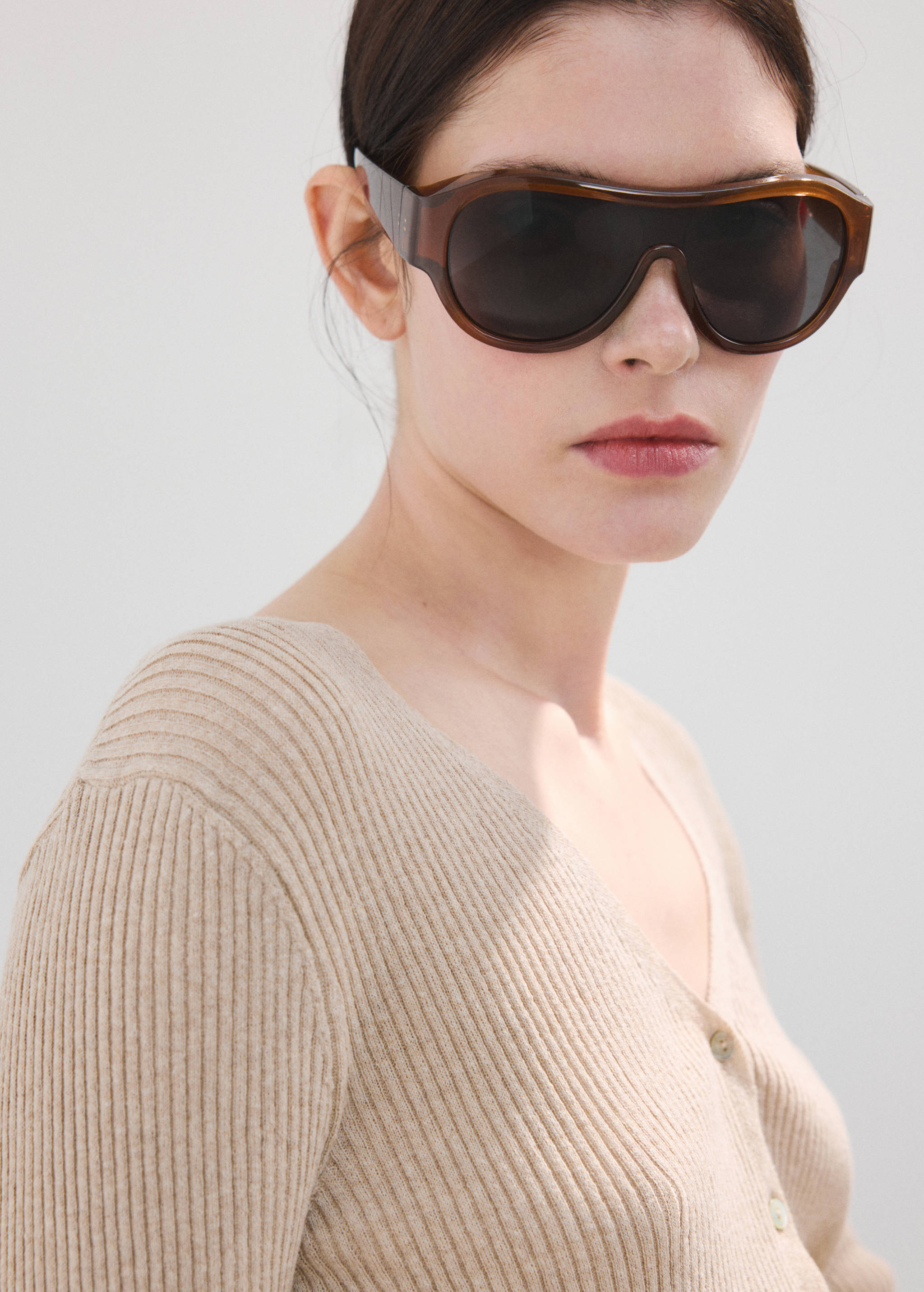 Beige ribbed V-neck cardigan with buttons.