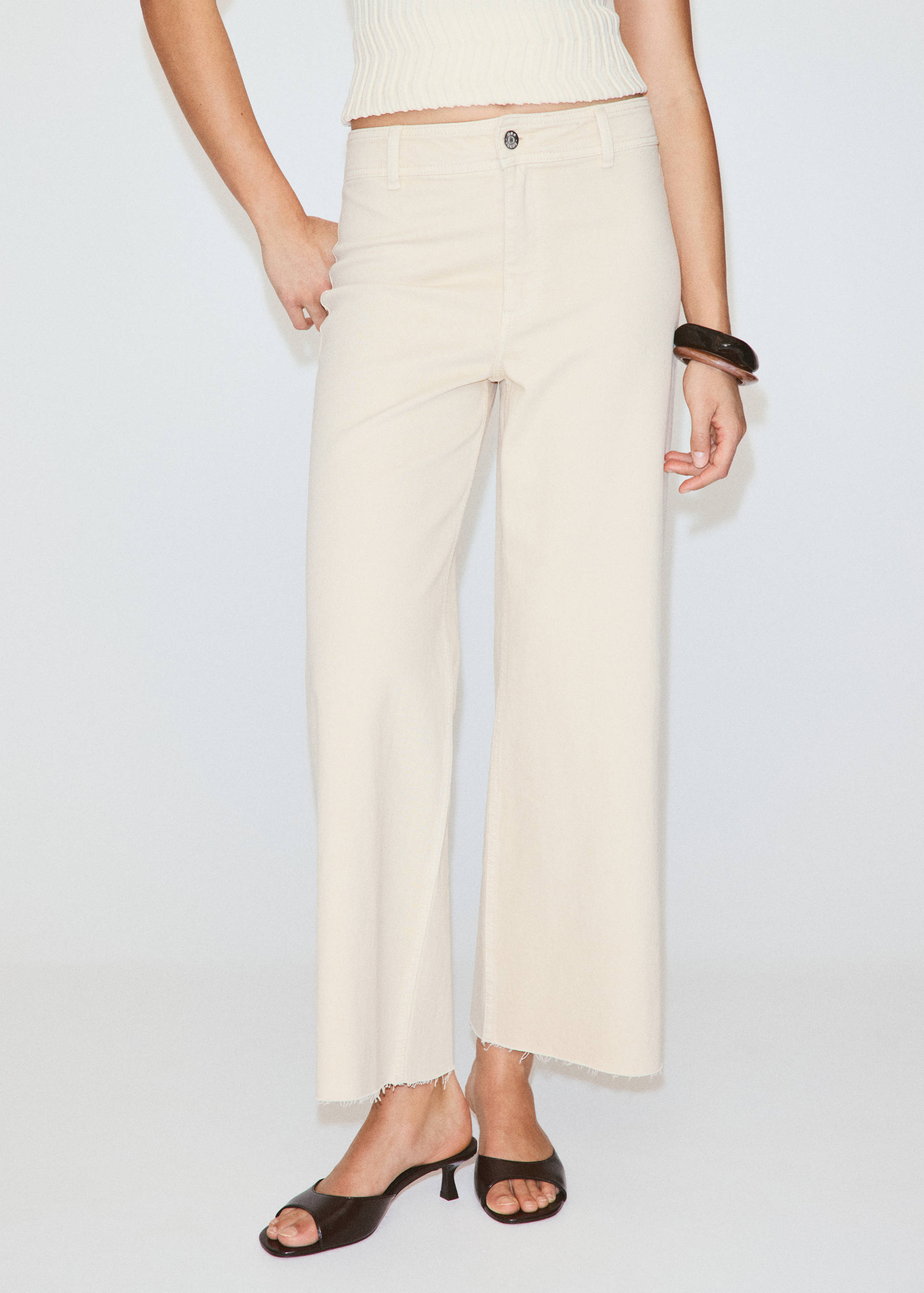Cream denim trousers with a straight fit, mid-rise waist, and cropped raw hems.