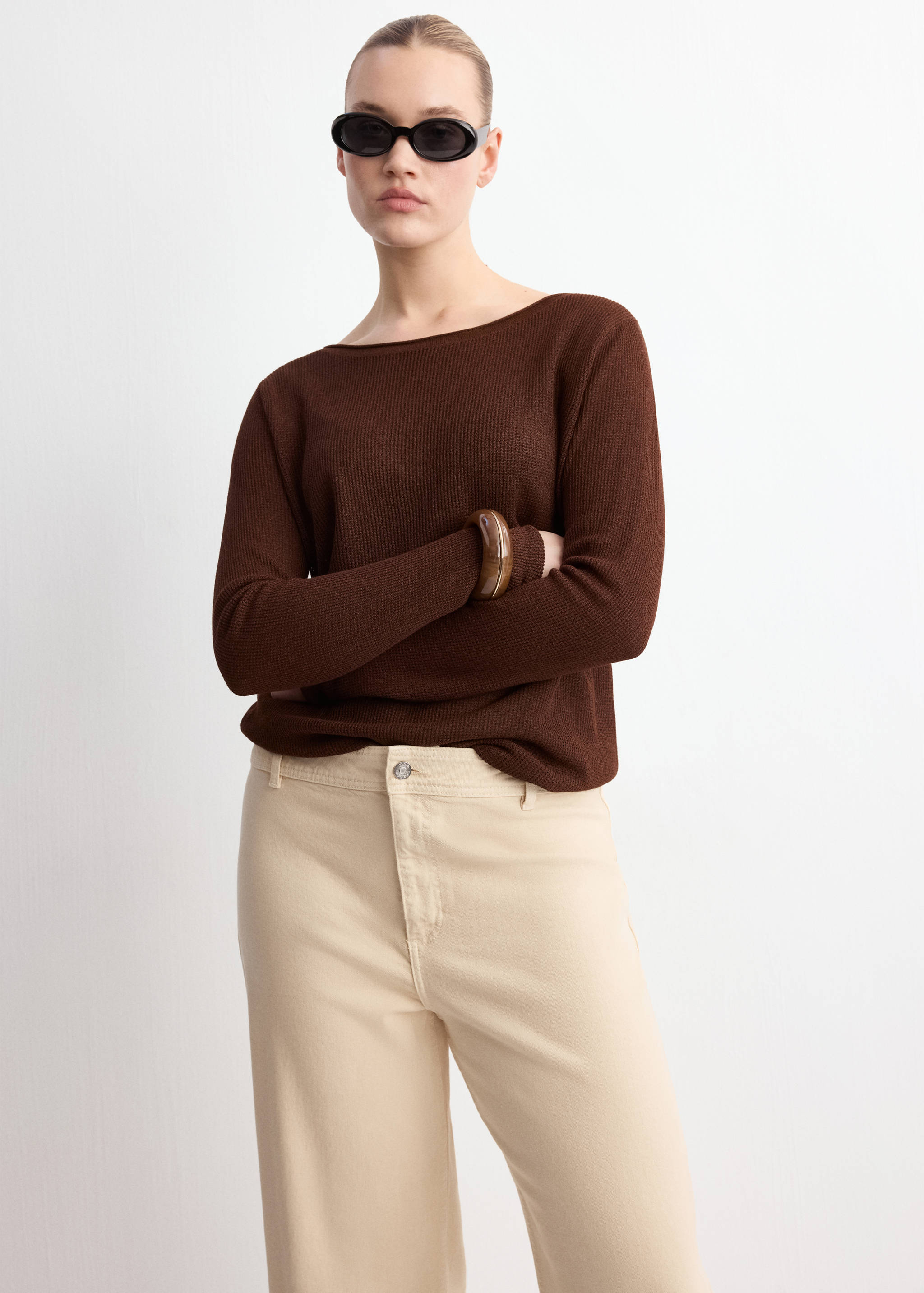 Cream wide-leg jeans paired with a dark brown knit sweater.