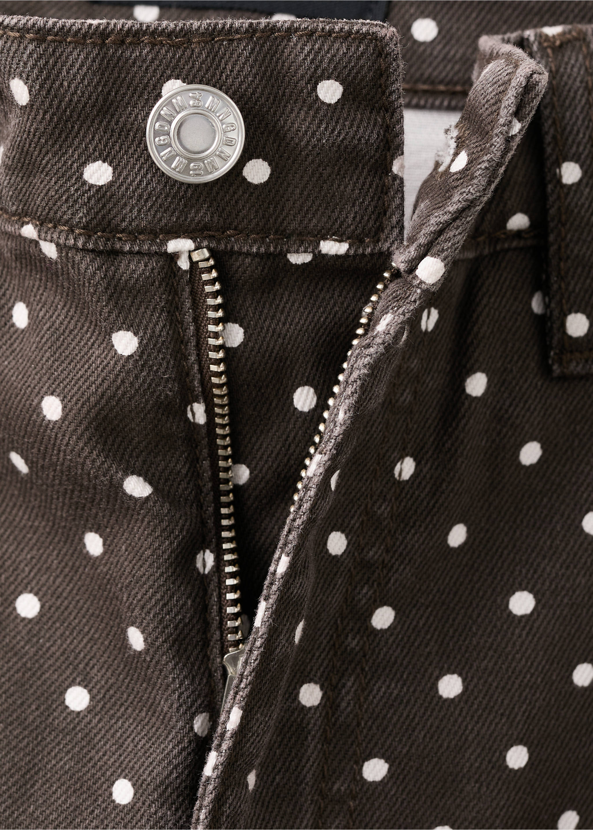 Close-up of brown denim trousers with a white polka dot pattern, metal button, and zipper., Chocolate. Ref: 27057159-00.