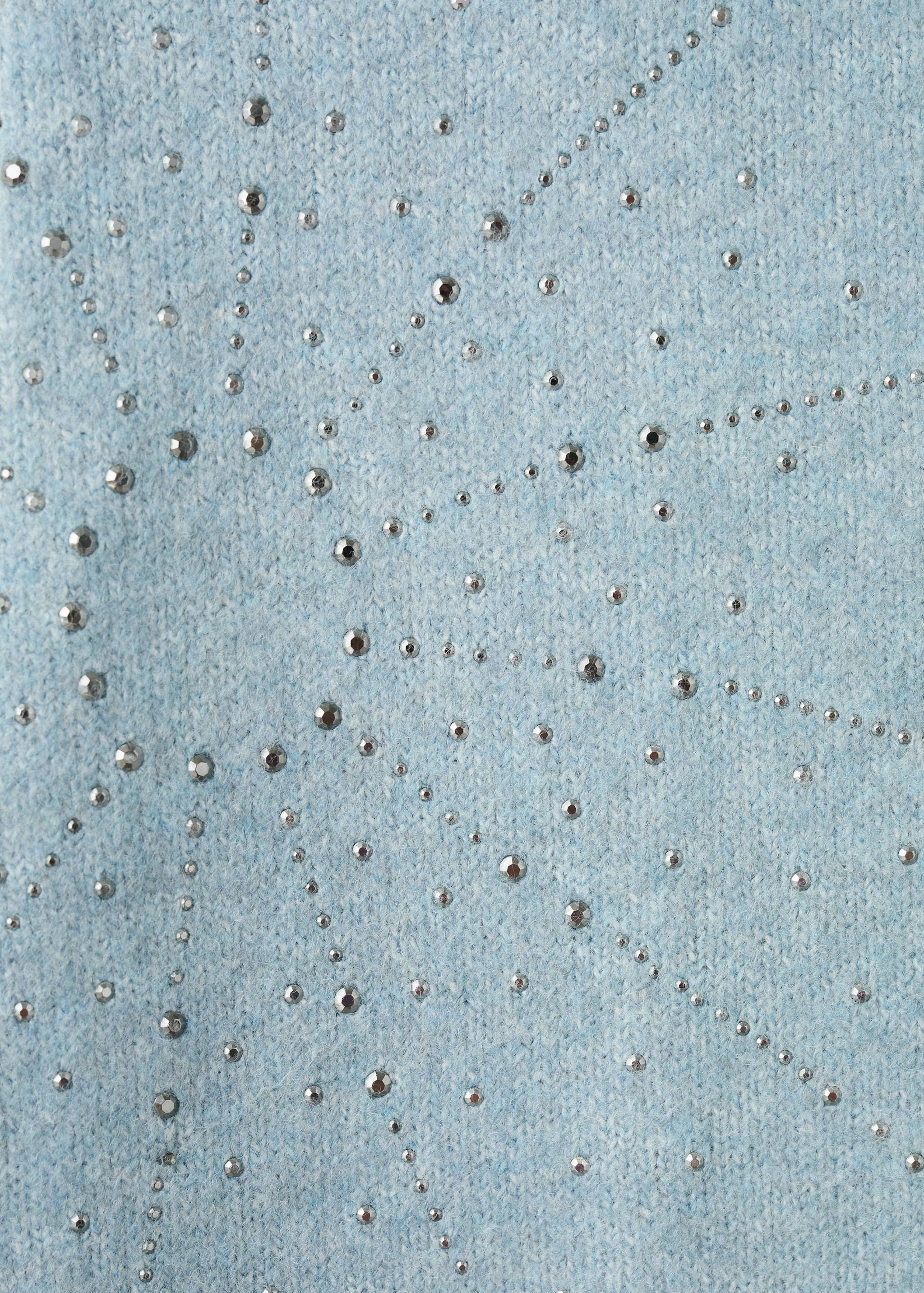Blue knitted sweater detail with silver studs.