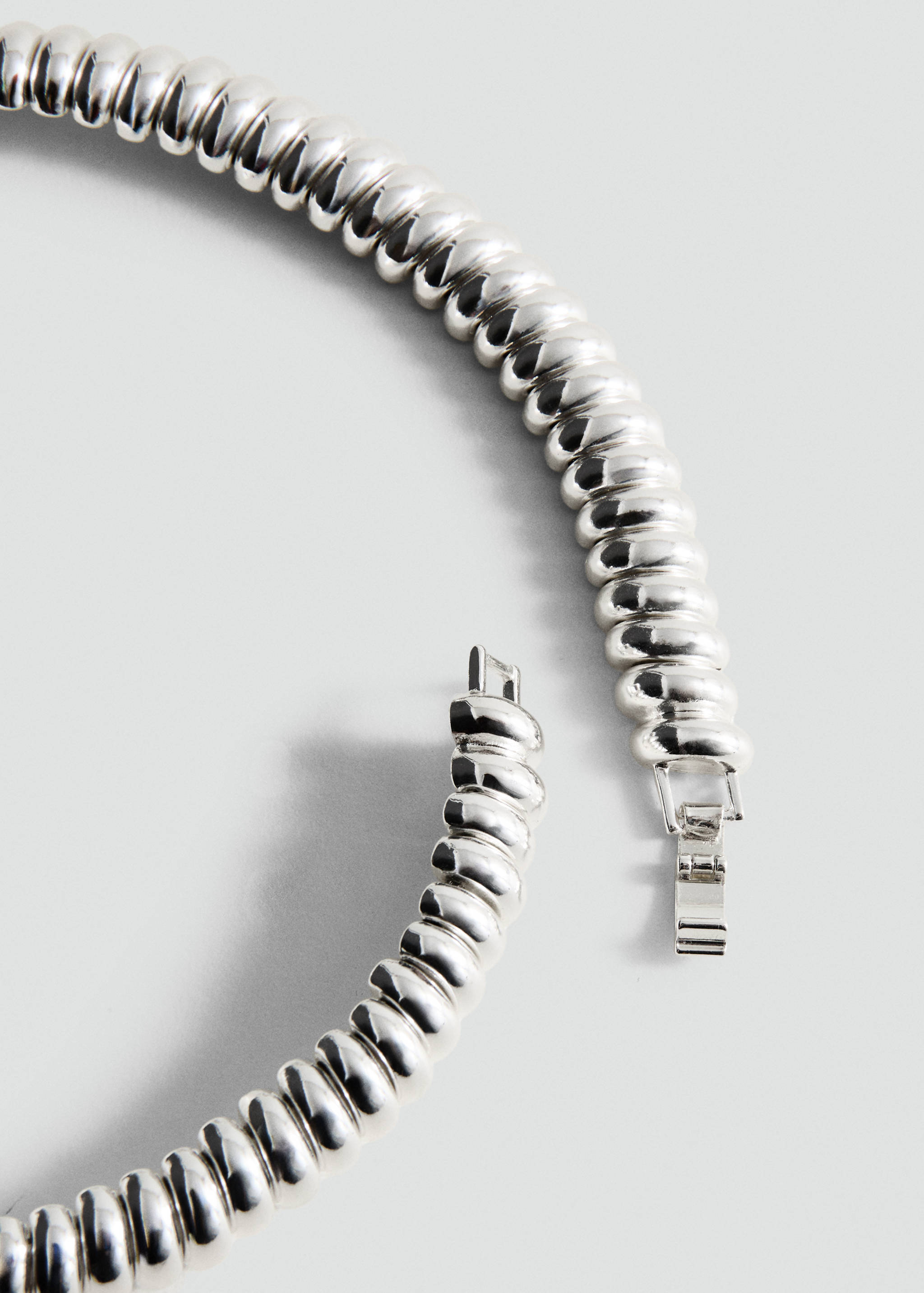 Silver-toned metallic collar necklace with a ridged, segmented design.