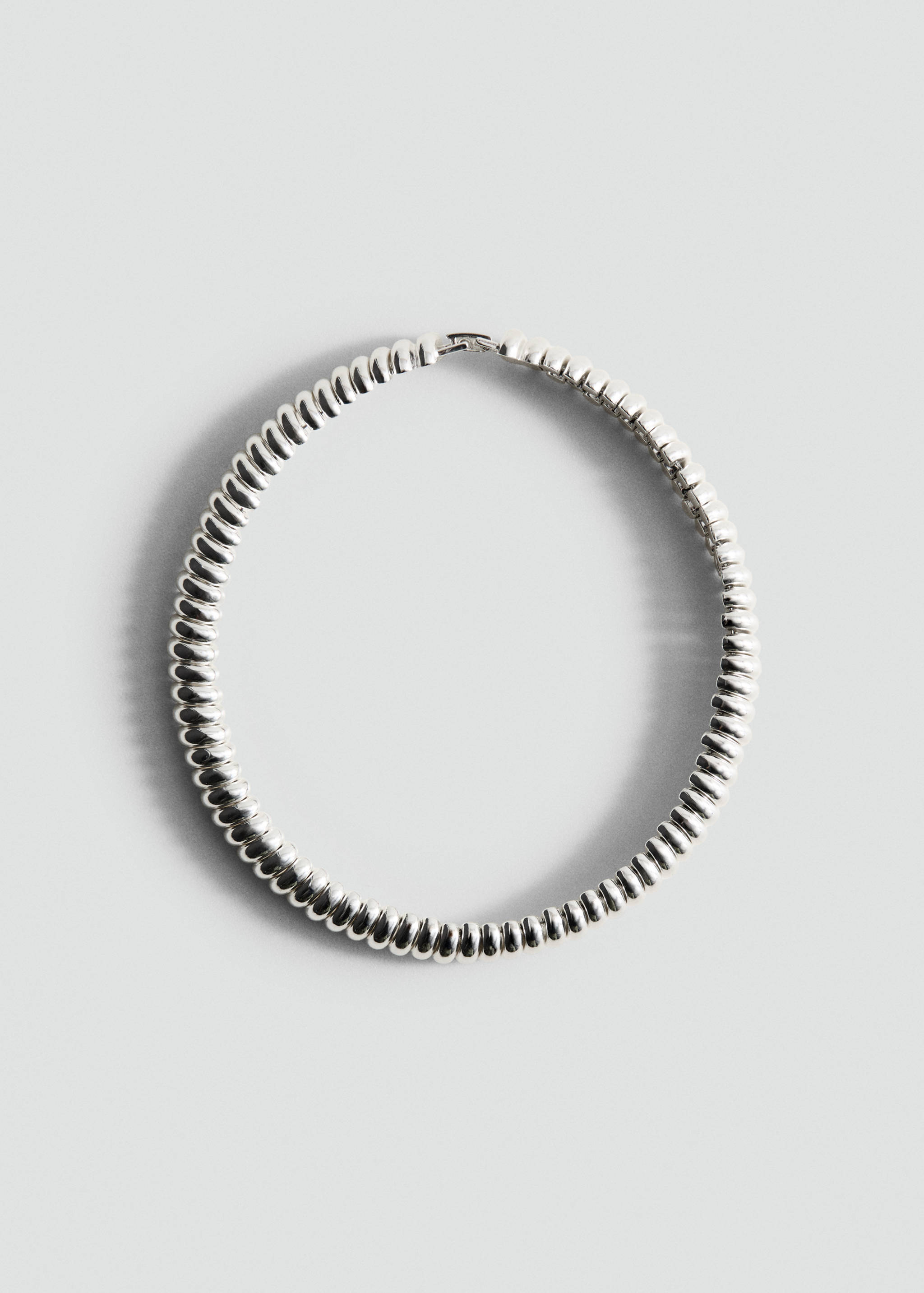 Silver-coloured textured collar necklace with a rounded beaded design.