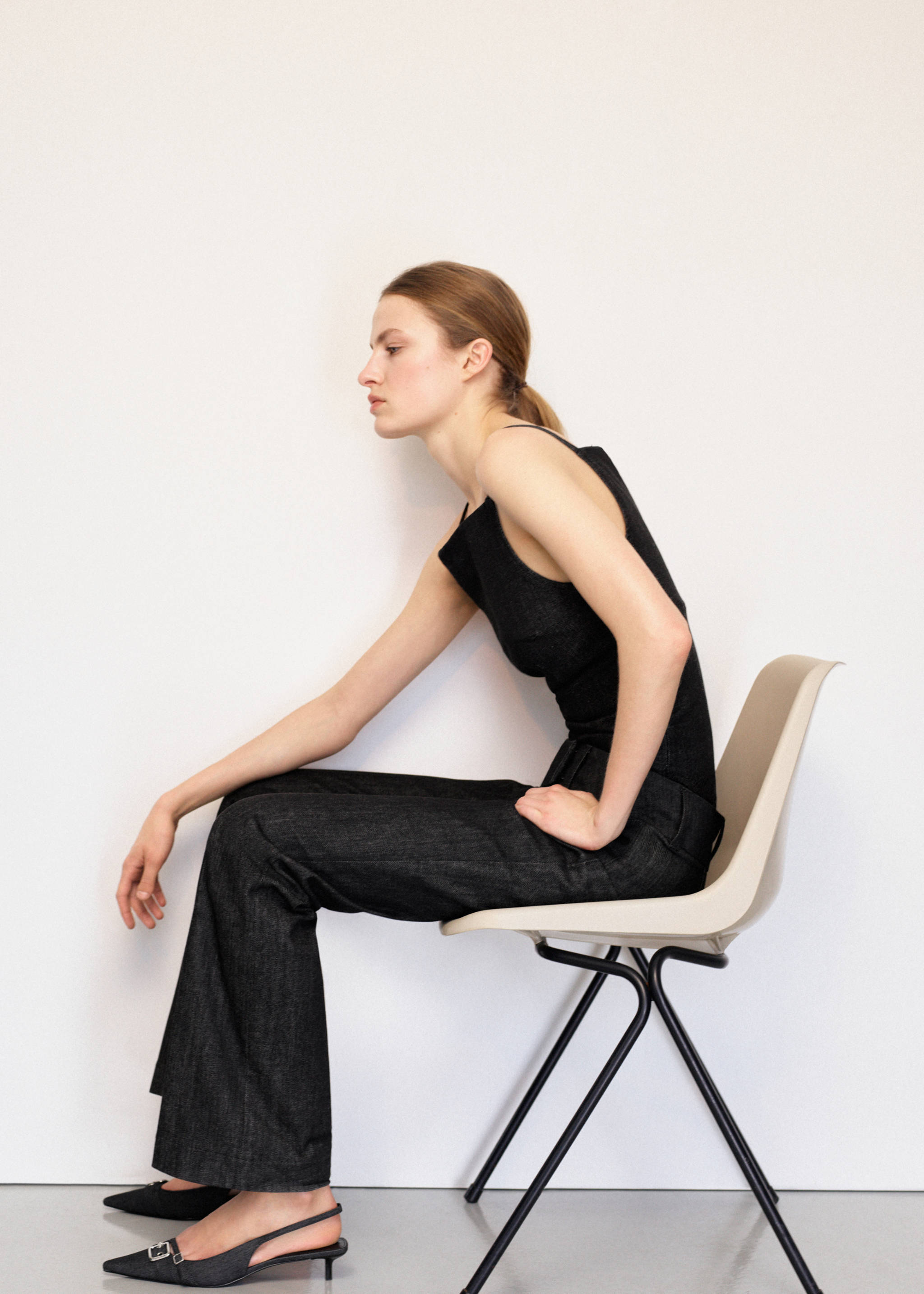 Dark denim trousers paired with a matching sleeveless top.
