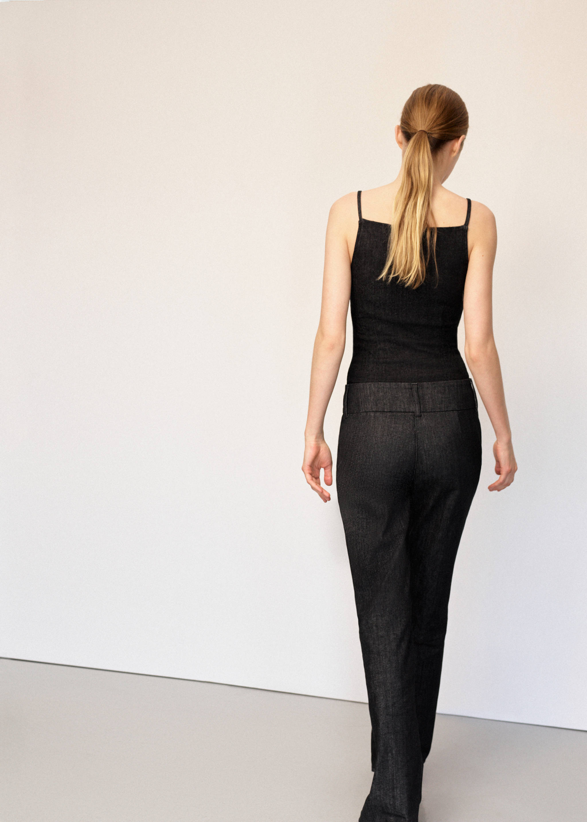 Dark denim trousers in a straight-leg fit, shown from the back.