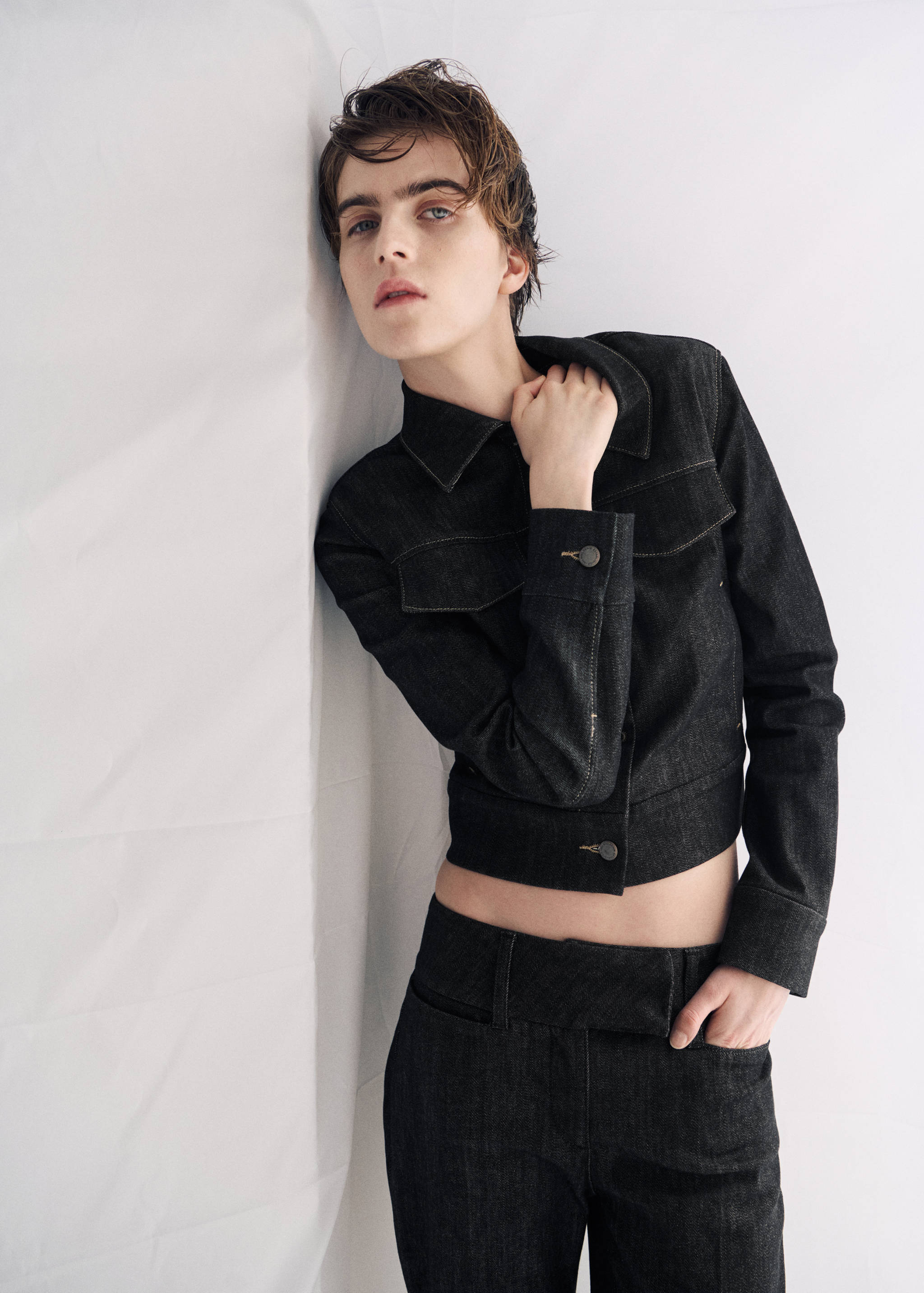 Dark denim jacket featuring a pointed collar, buttoned cuffs, and flap pockets.