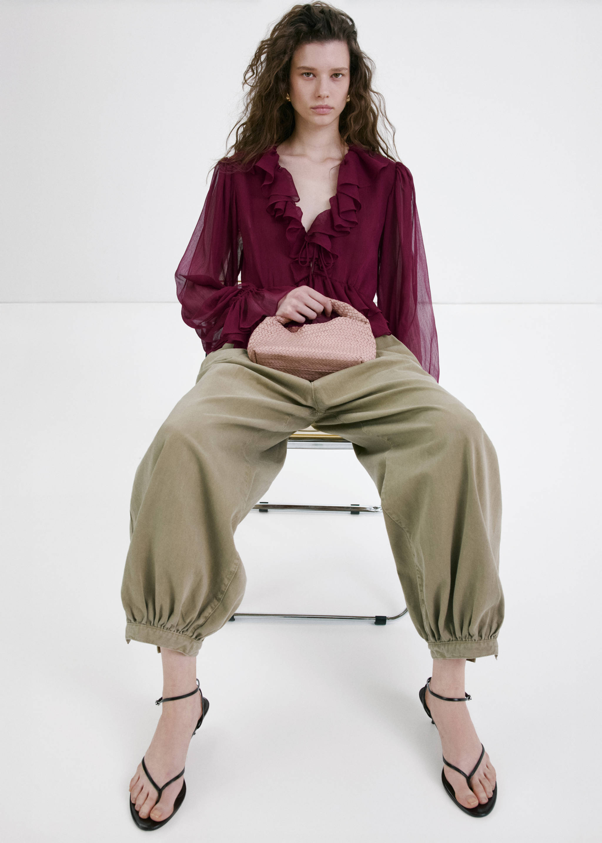Burgundy ruffled V-neck blouse with long sheer sleeves.