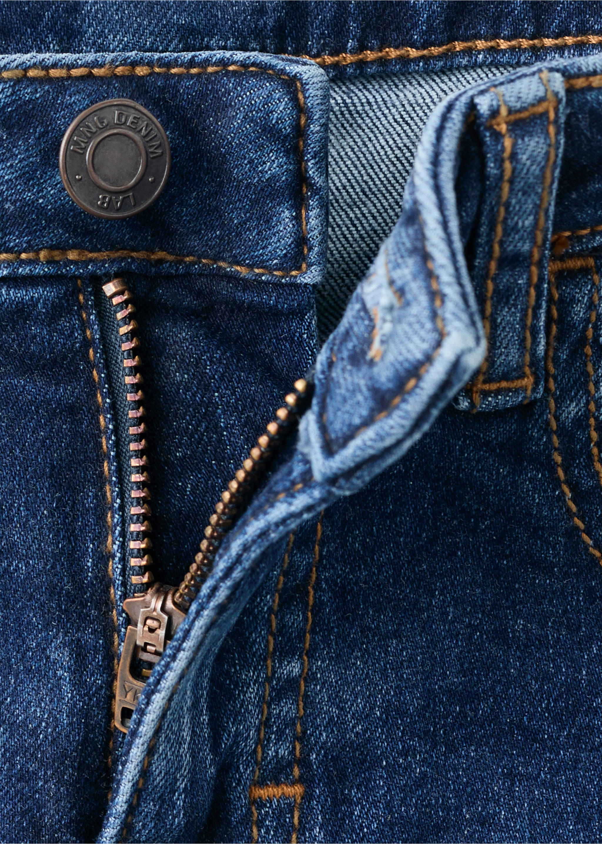 Close-up of blue denim trousers with a metal button and zip fly., Dark Blue. Ref: 27071259-00.