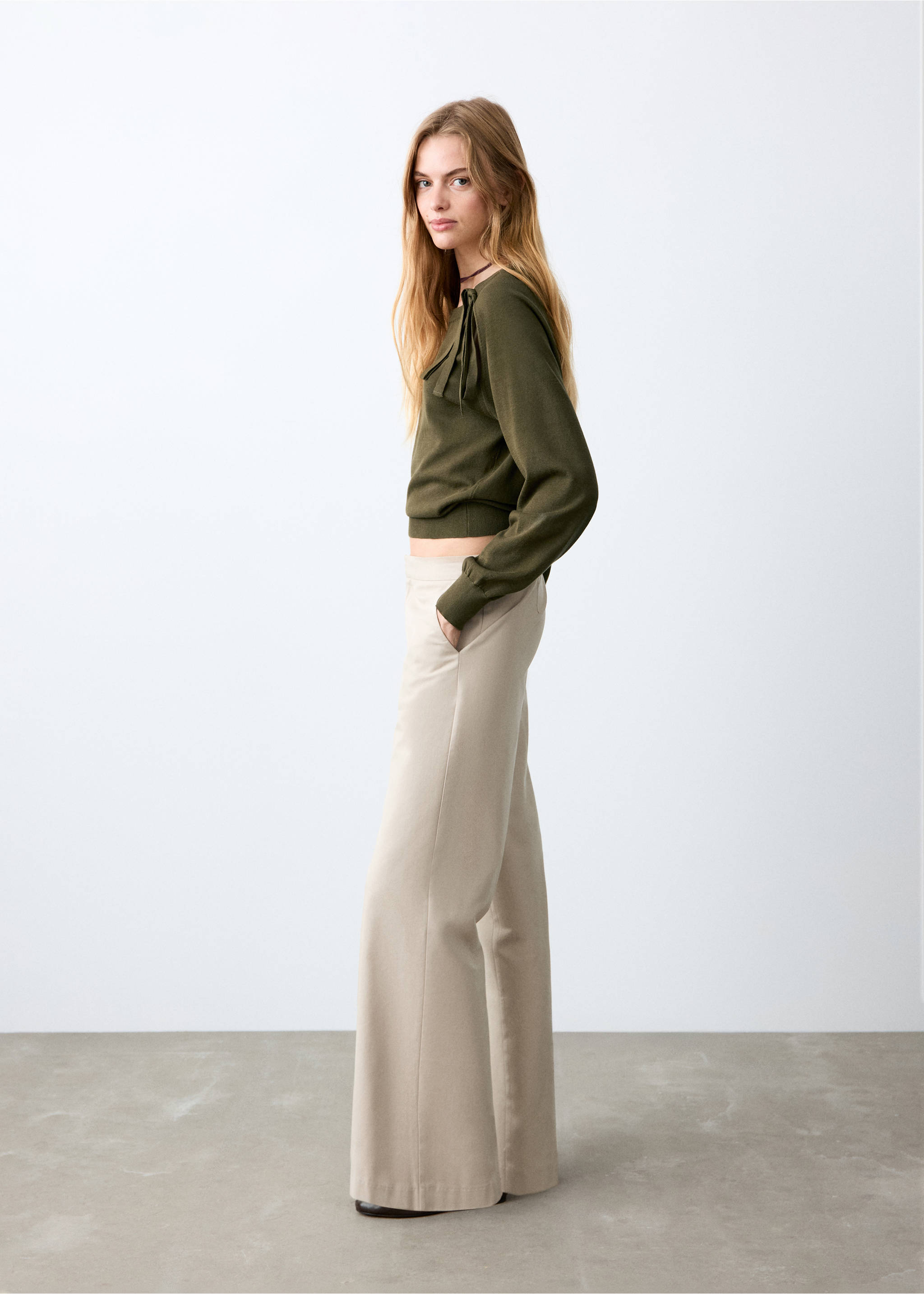 Cream wide-leg trousers worn with an olive green long-sleeve sweater., Beige. Ref: 27072549-00.