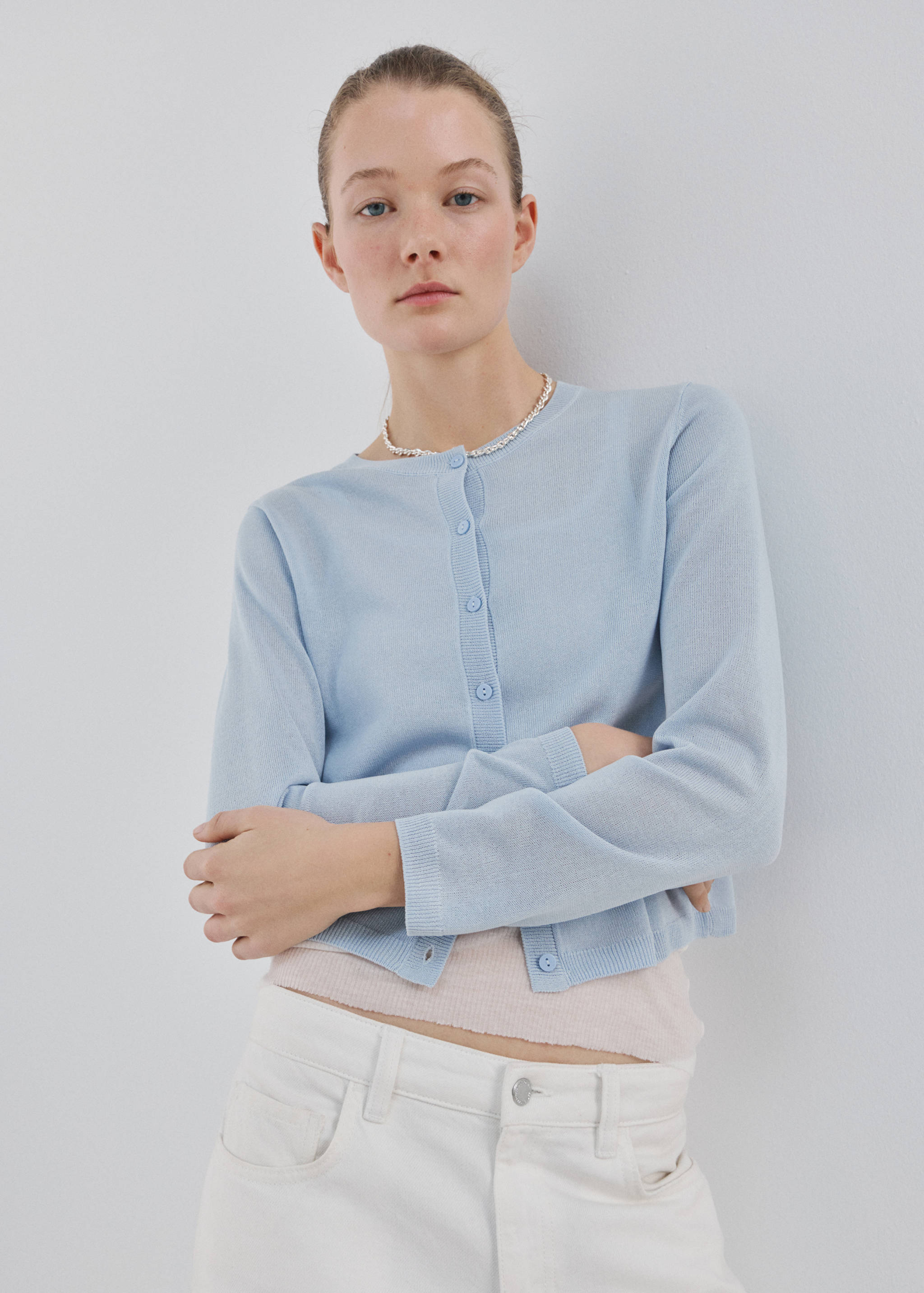Light blue knitted cardigan with a round neckline and button fastening.