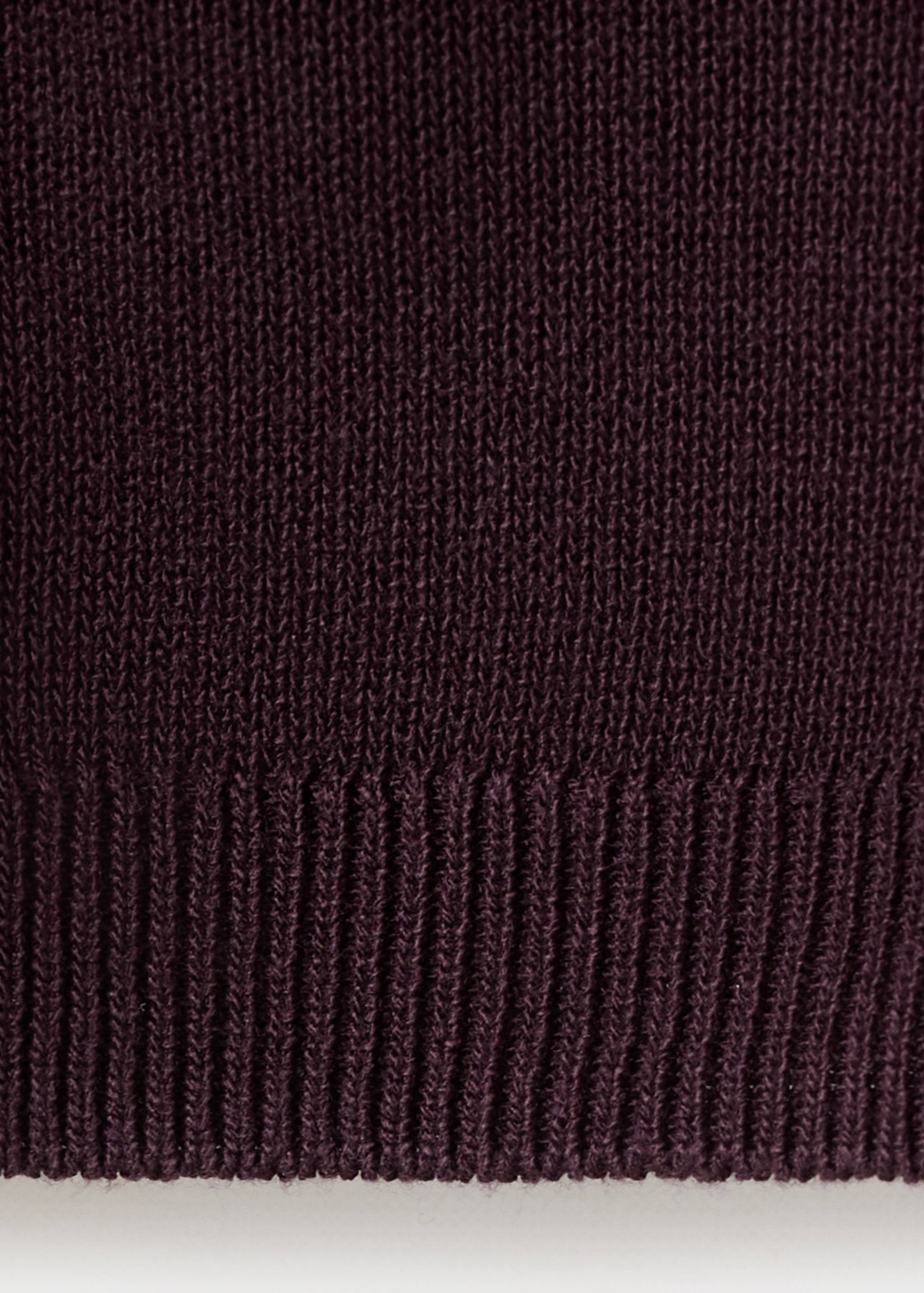 Burgundy cardigan knit fabric detail showing ribbed hem.