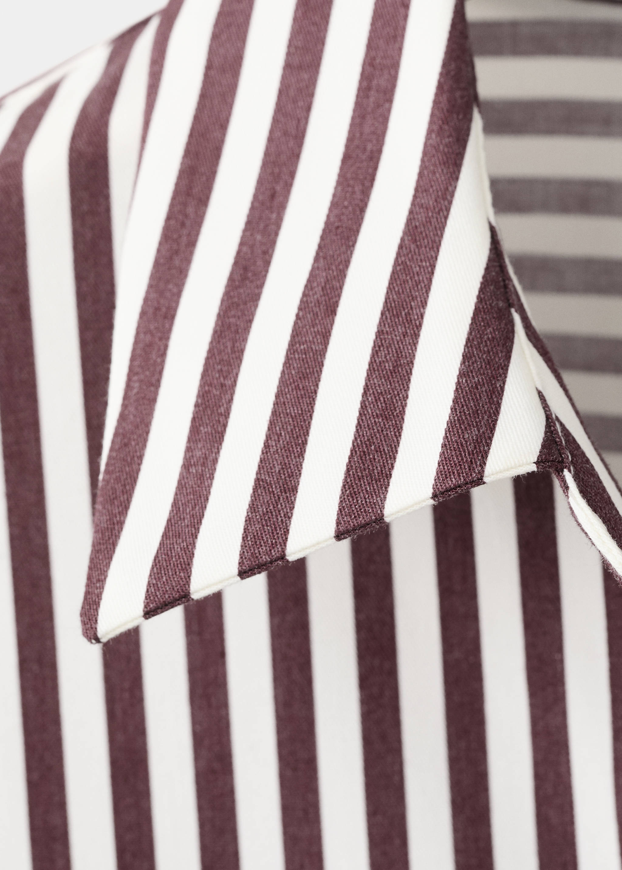 Close-up of a burgundy and white striped shirt collar.
