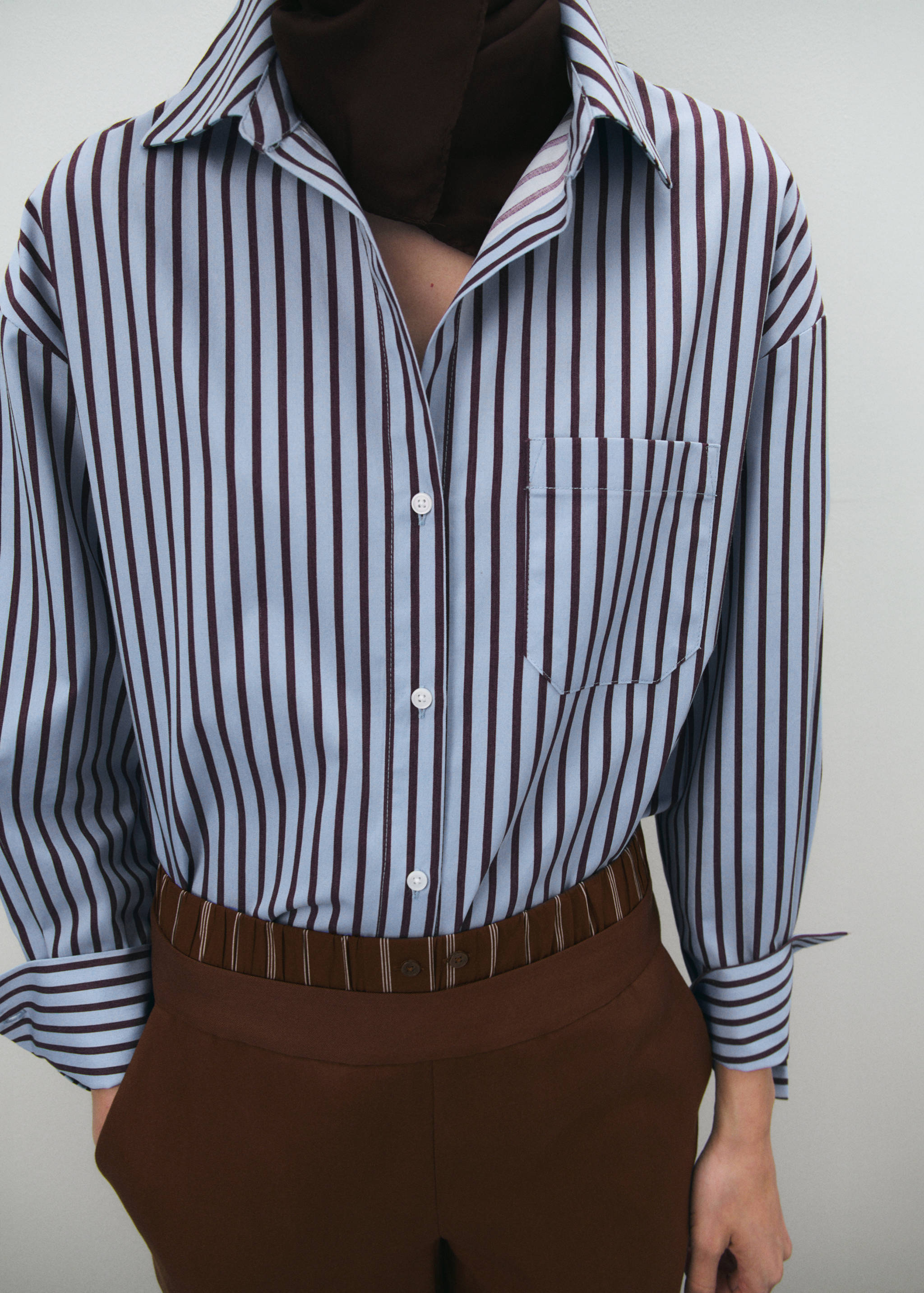Light blue and dark brown striped shirt with a classic collar and front buttons.