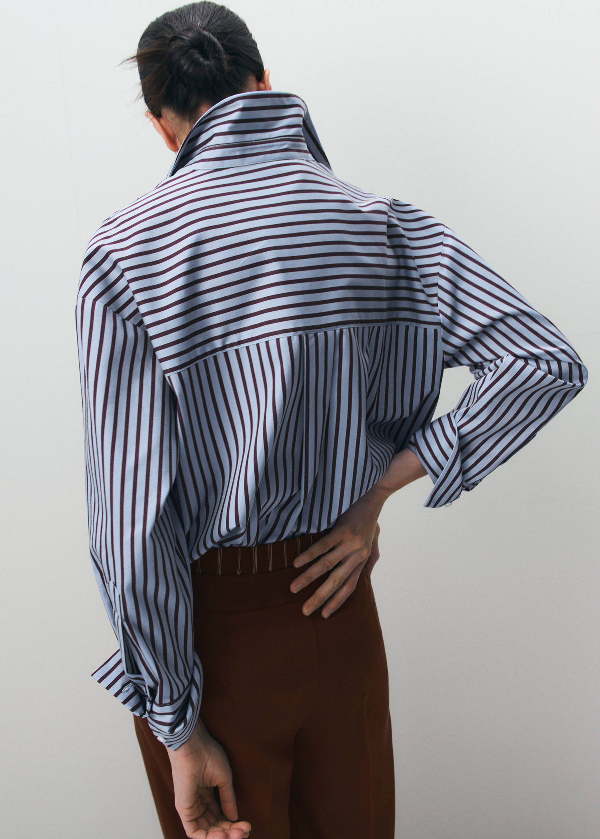 Blue and maroon striped shirt with a high turned-up collar, back view.