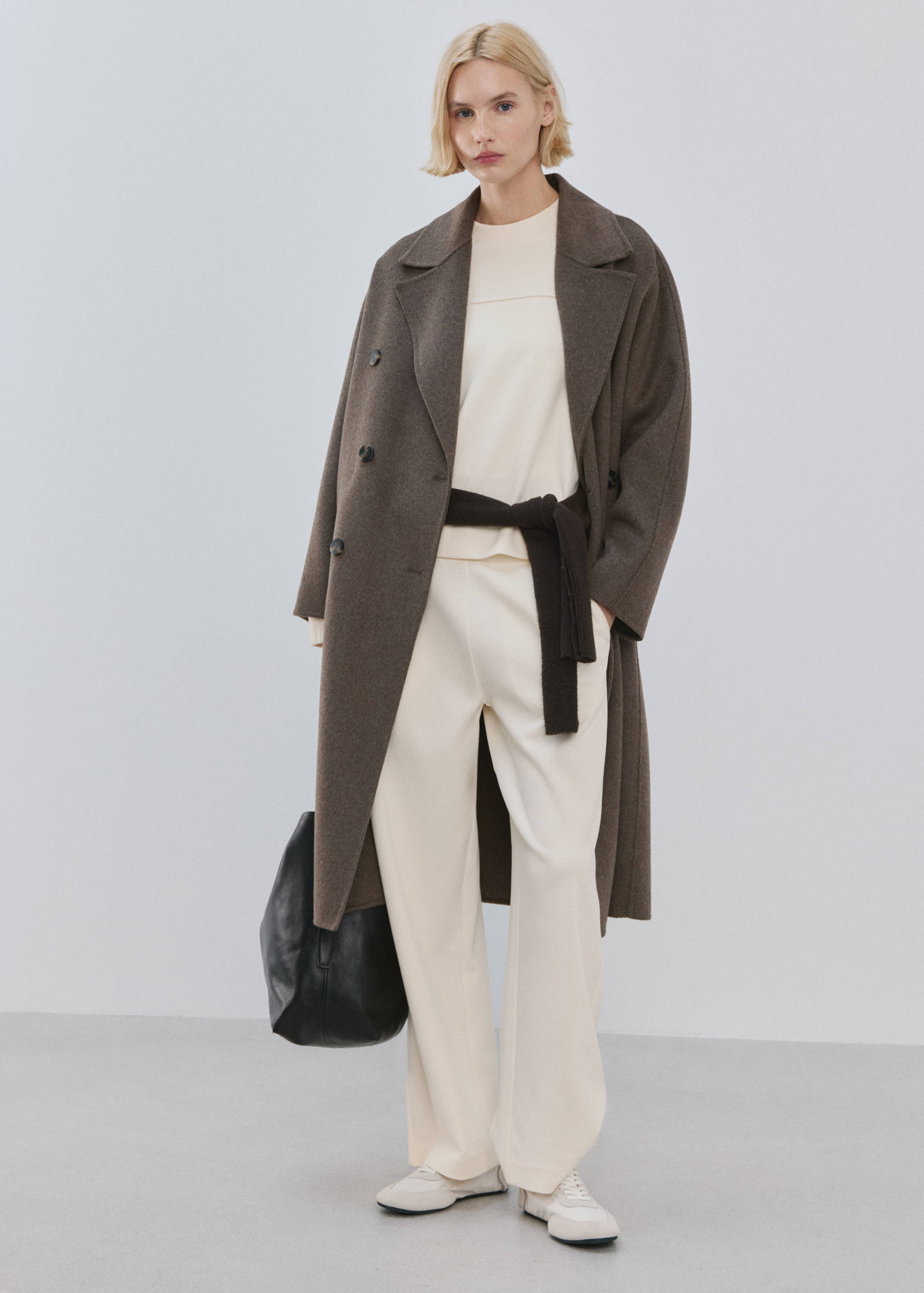 Cream sweatshirt with a relaxed fit and crew neck, styled in a complete outfit.