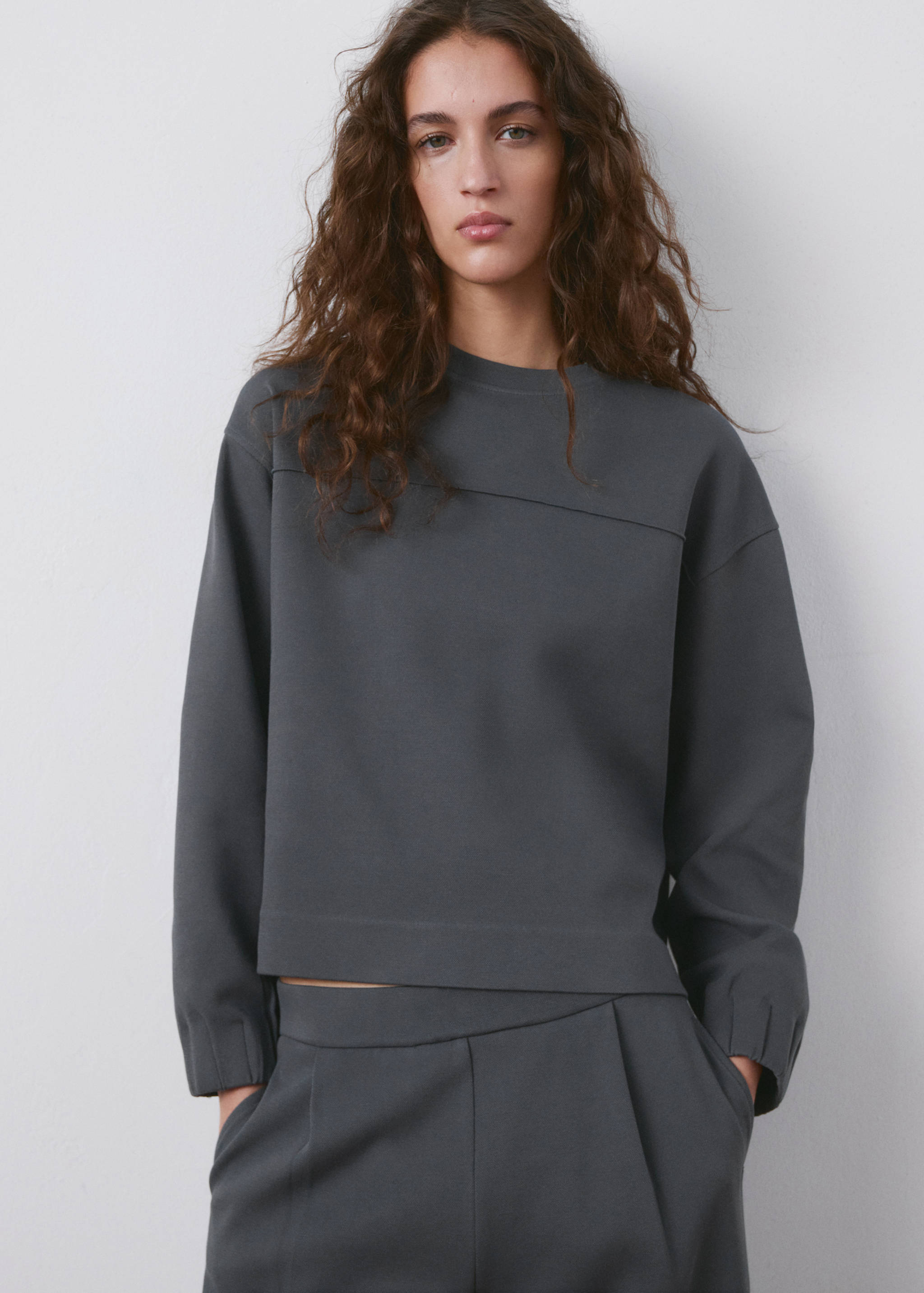 Dark grey crew neck sweatshirt with a relaxed fit and long sleeves.