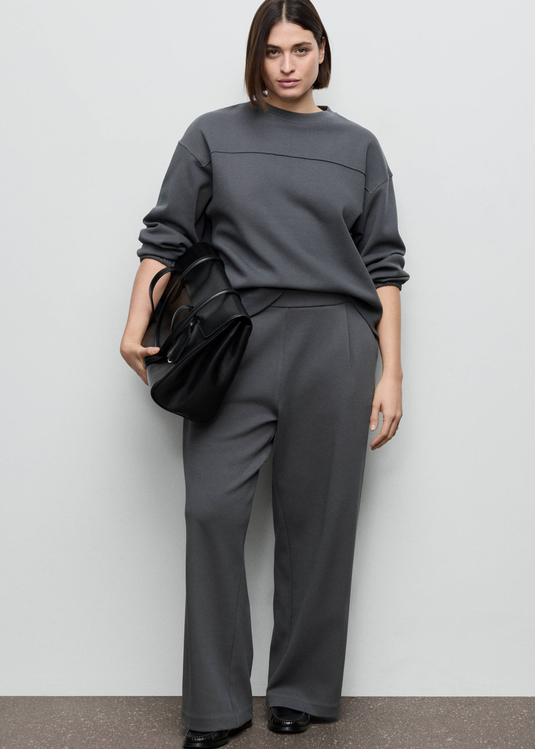 Dark grey crew-neck sweatshirt with long sleeves and a matching wide-leg pair of trousers.