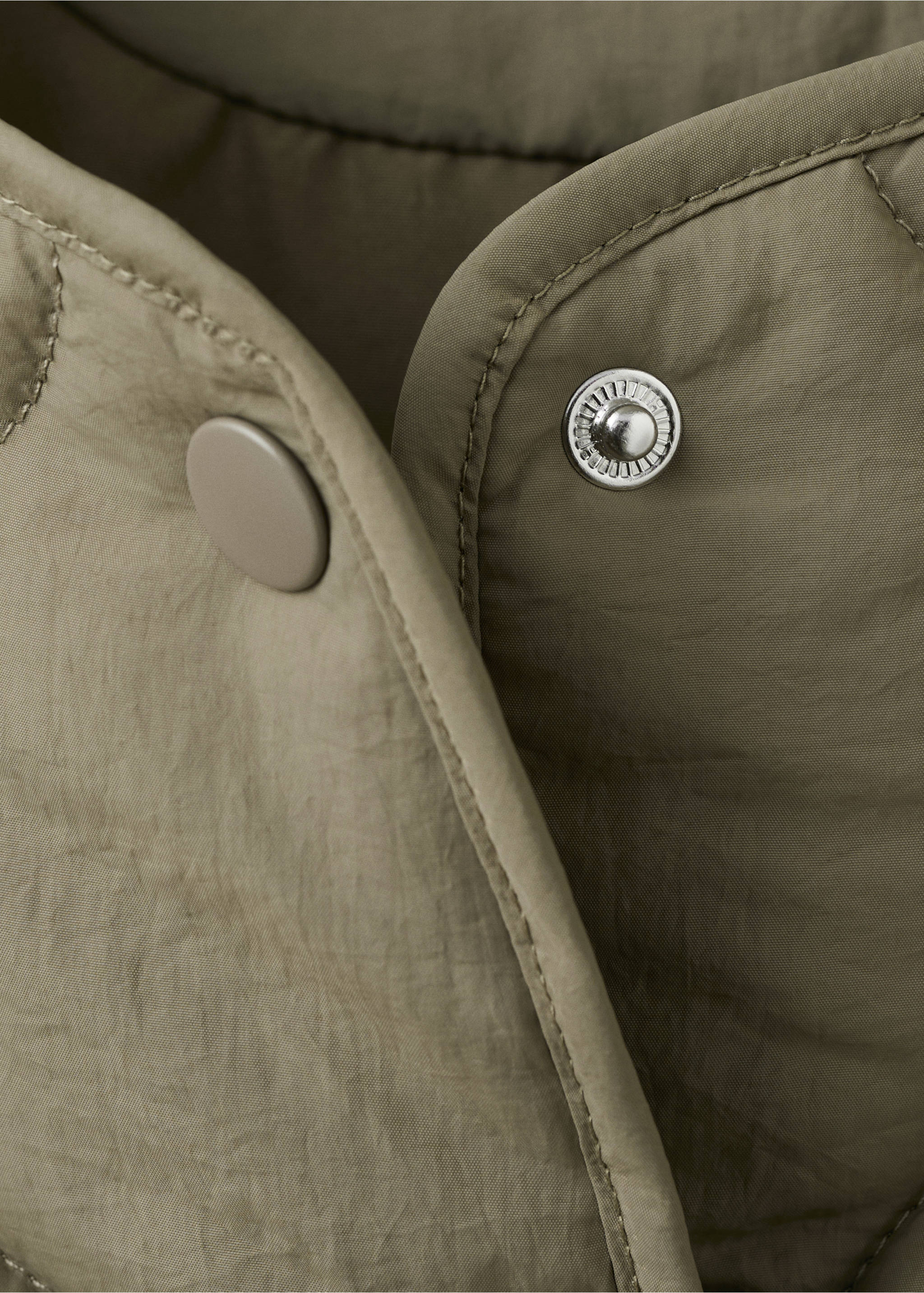 Close-up of a khaki green parka showing its metallic snap button detail., Khaki. Ref: 27084432-00.