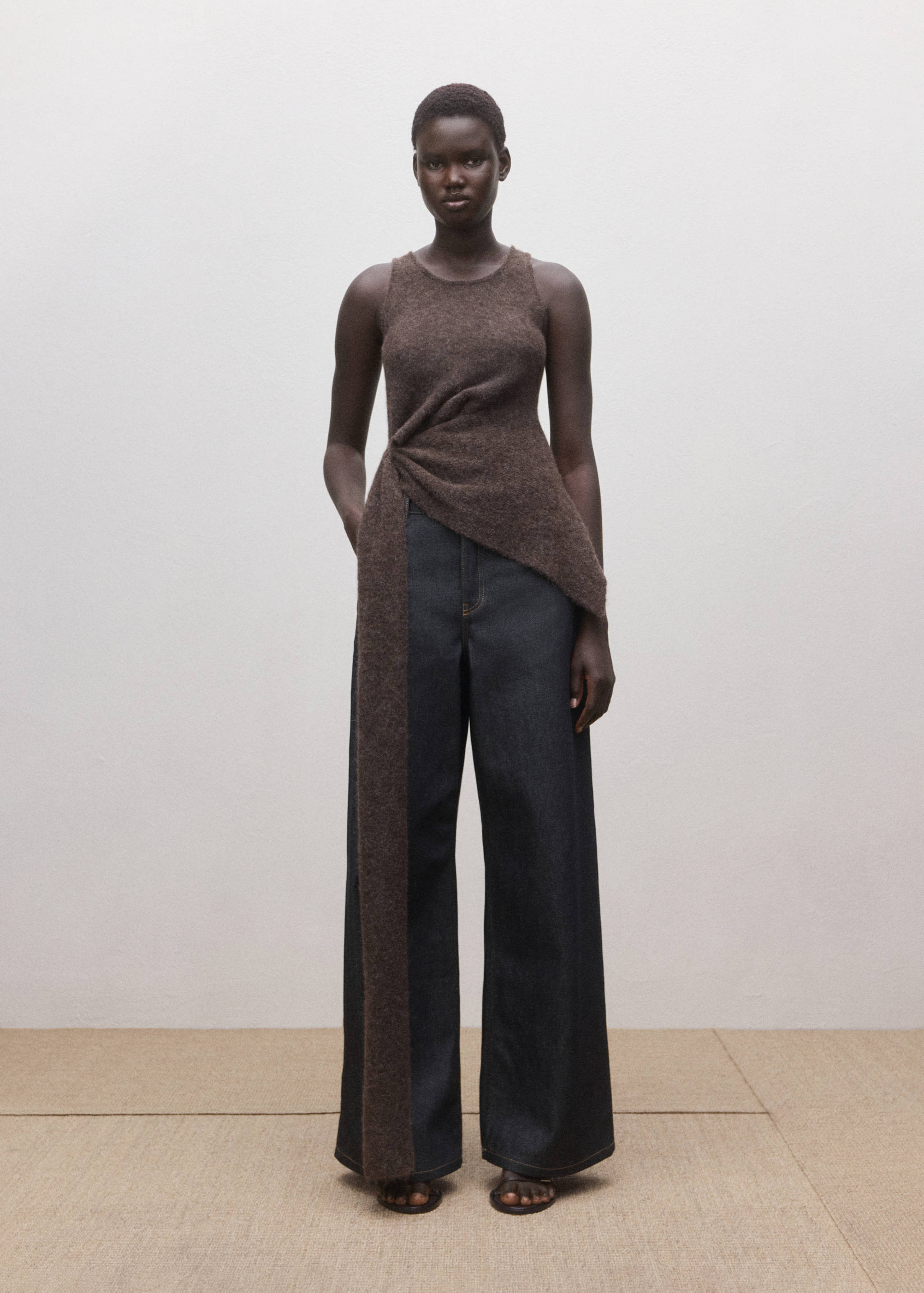 Dark wash denim trousers worn with a brown sleeveless knit top, Open Blue. Ref: 27084445-00.