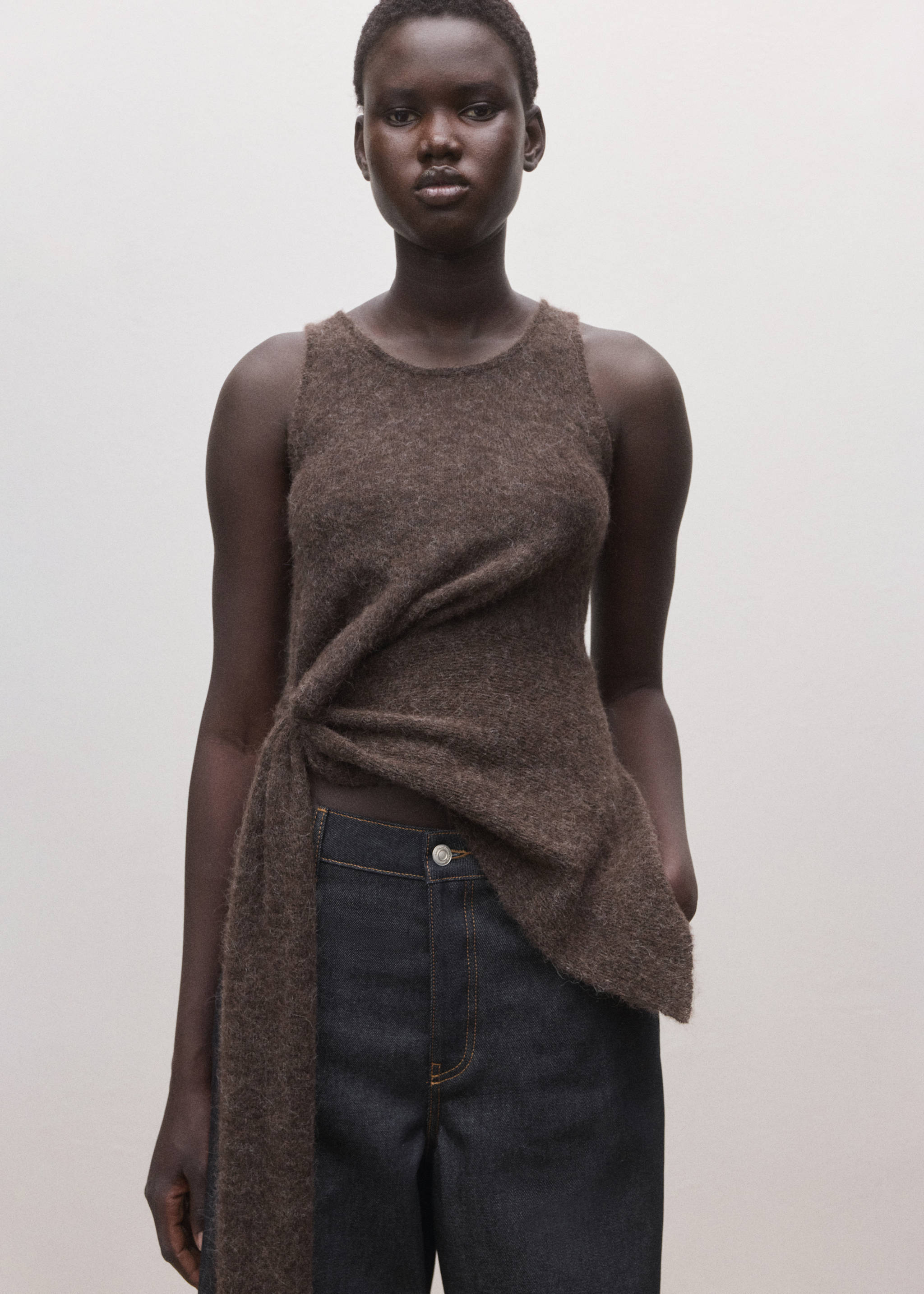 Dark brown textured sleeveless top with front twist knot and long sash.