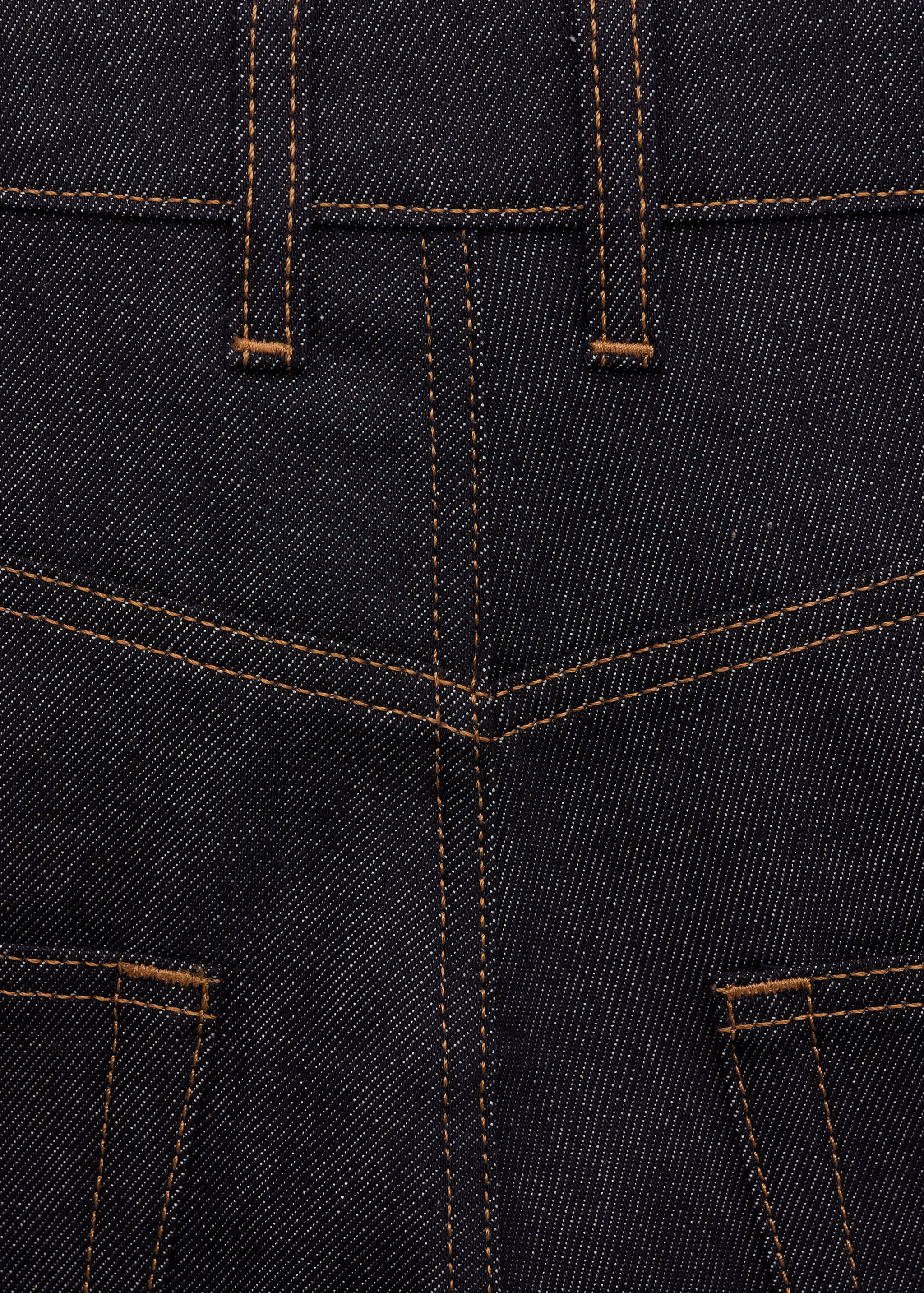 Dark blue denim fabric detail with contrast orange topstitching.