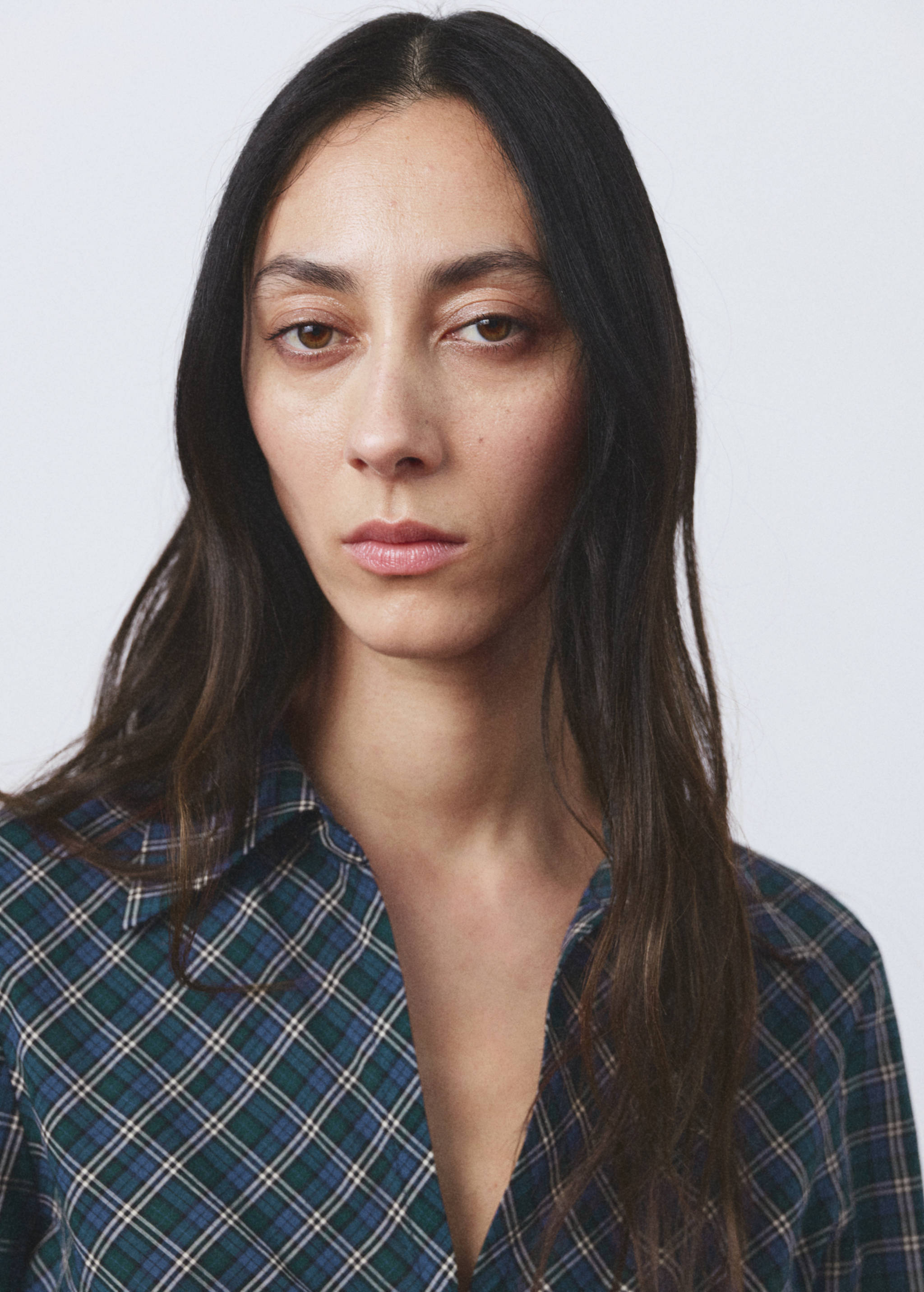 Close-up of a green and blue plaid blouse with a collar.