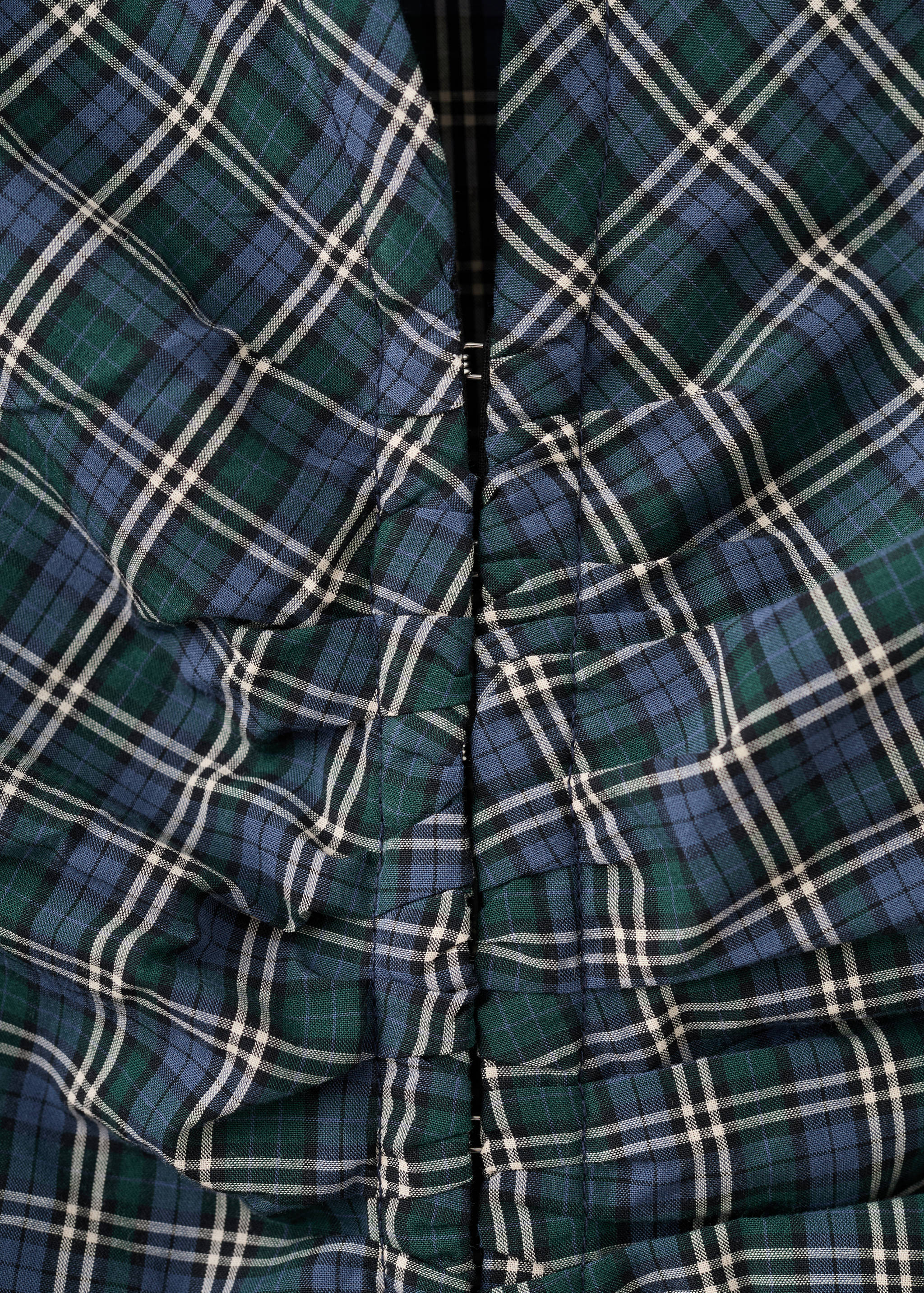 Green and blue tartan plaid blouse fabric close-up with ruching.