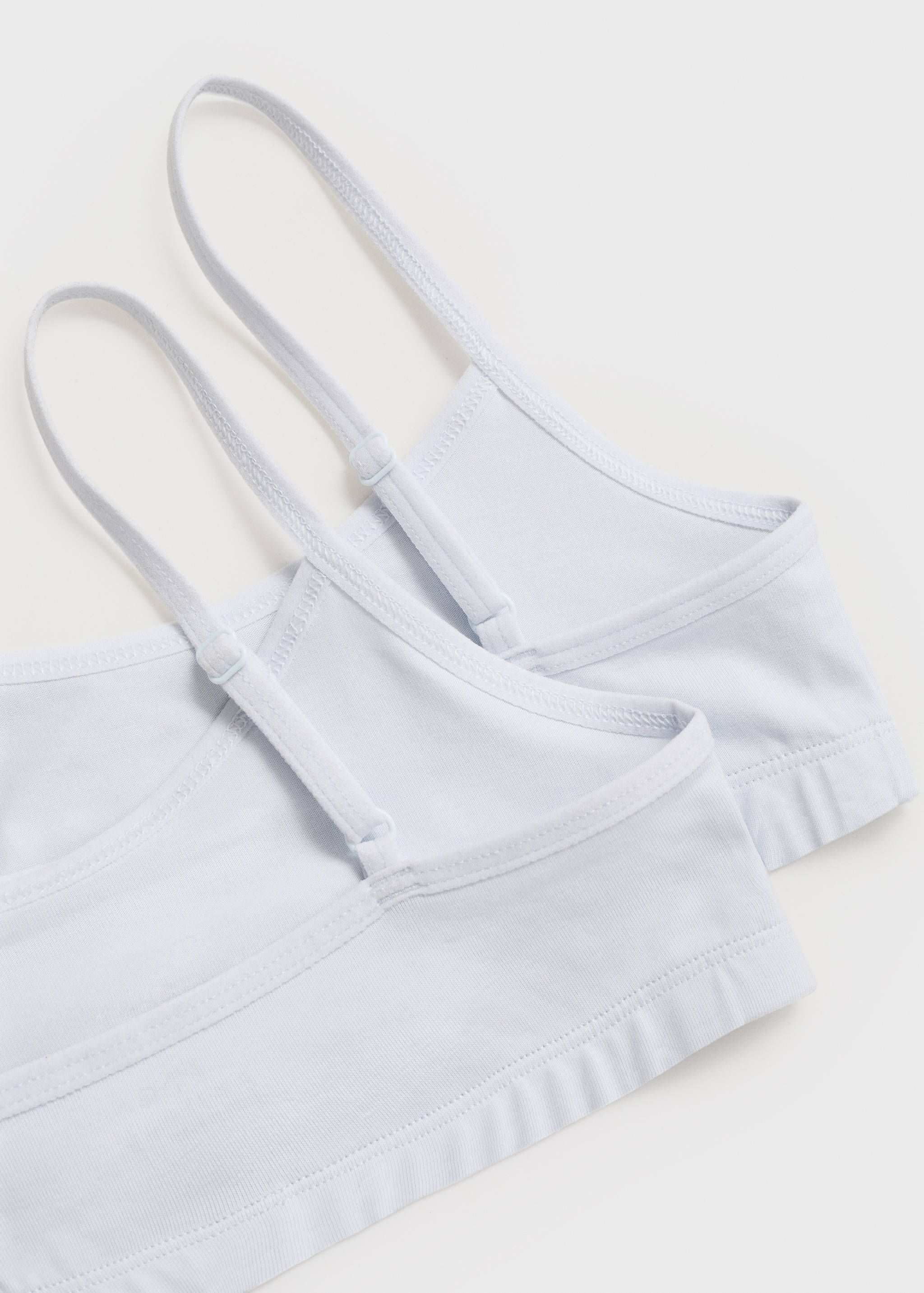 White bralette detail showing thin adjustable straps and elasticated underband.
