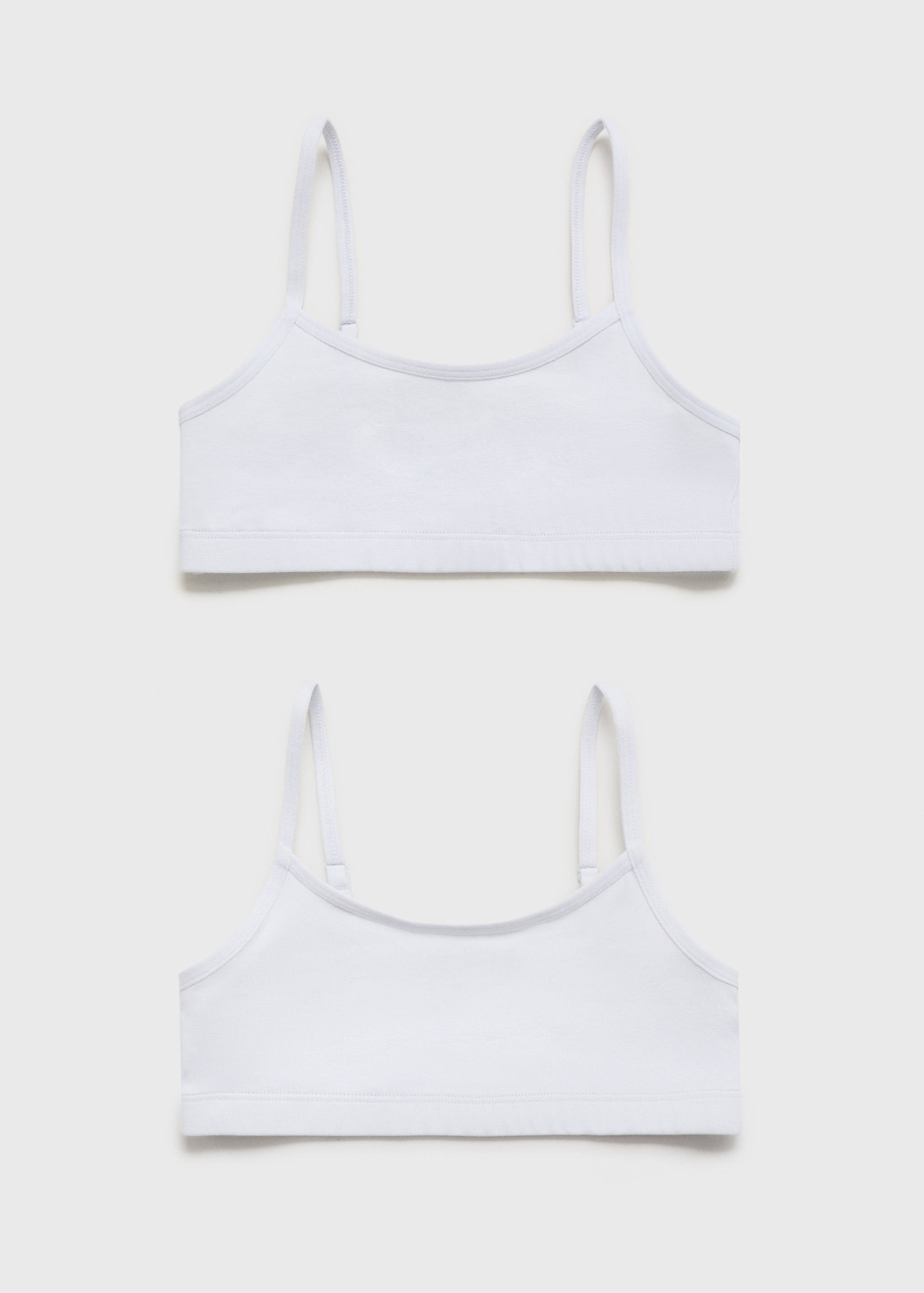 Set of two white bralettes with thin adjustable straps and elastic bands.