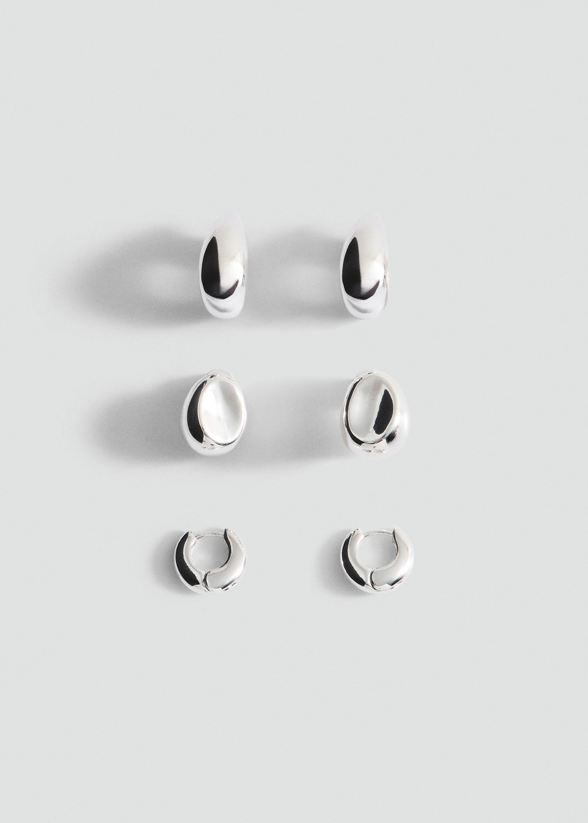 Set of three pairs of shiny silver-toned hoop earrings.